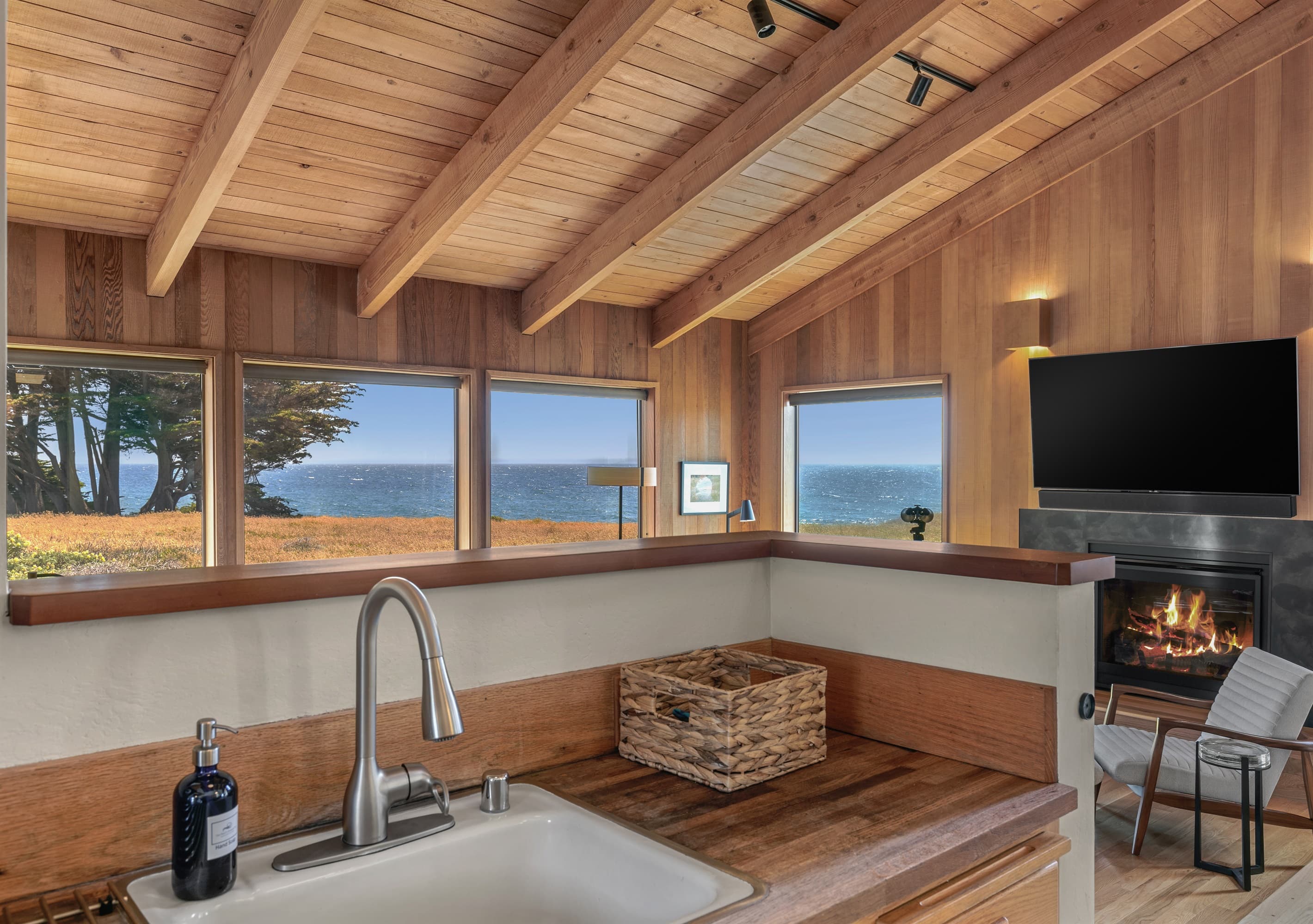Coastal refinement meets comfort: Enjoy sweeping ocean views, warm wood interiors, and a fireside lounge—all from the heart of this elegantly appointed kitchen designed for serene, upscale living.