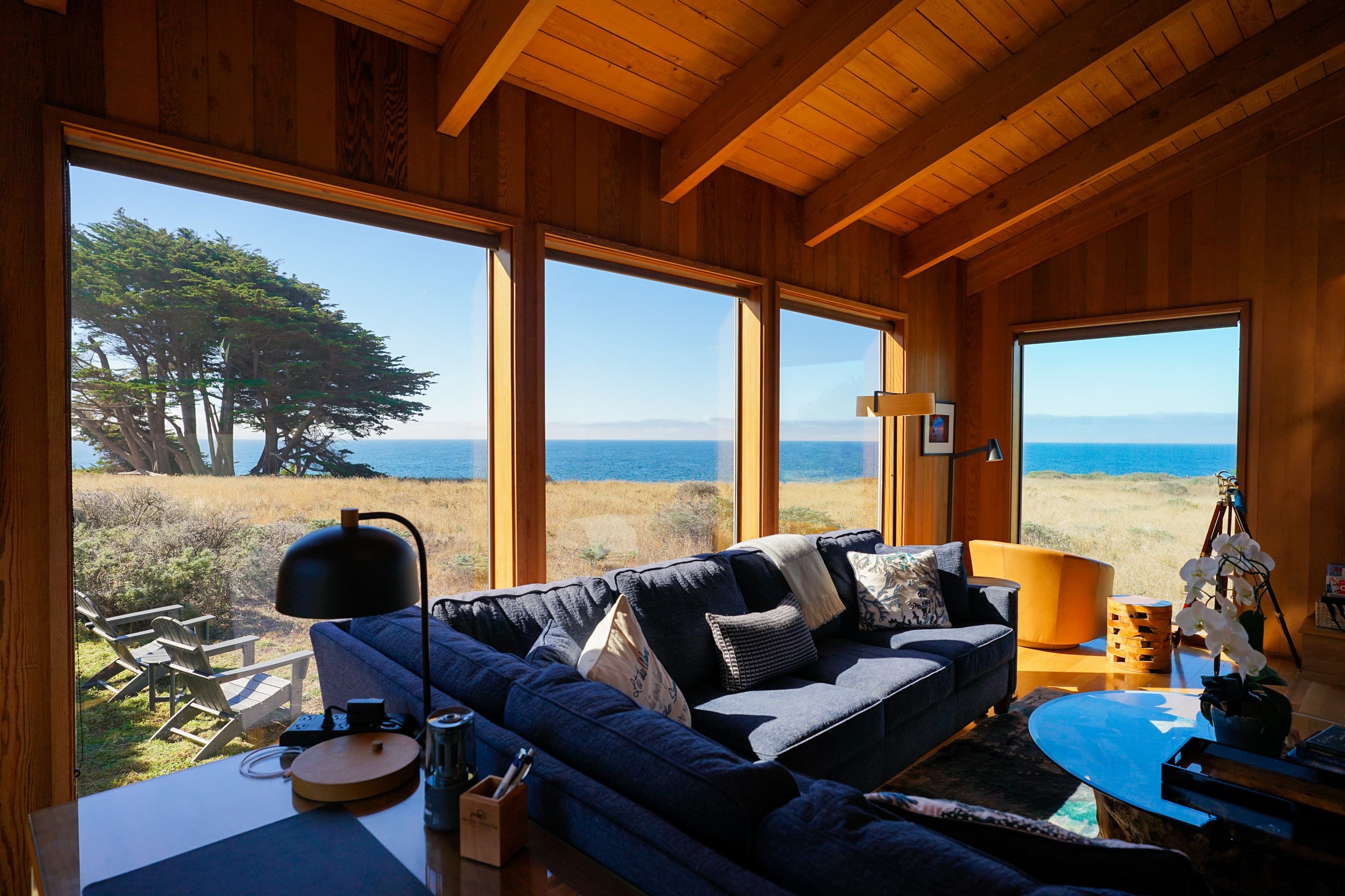 "The view from the living room was amazing- a cypress tree and the ocean with sufficient privacy from those walking by the ocean."  Views reveal an inspiring coastal panorama through expansive windows  in a serene, light-filled living space. 