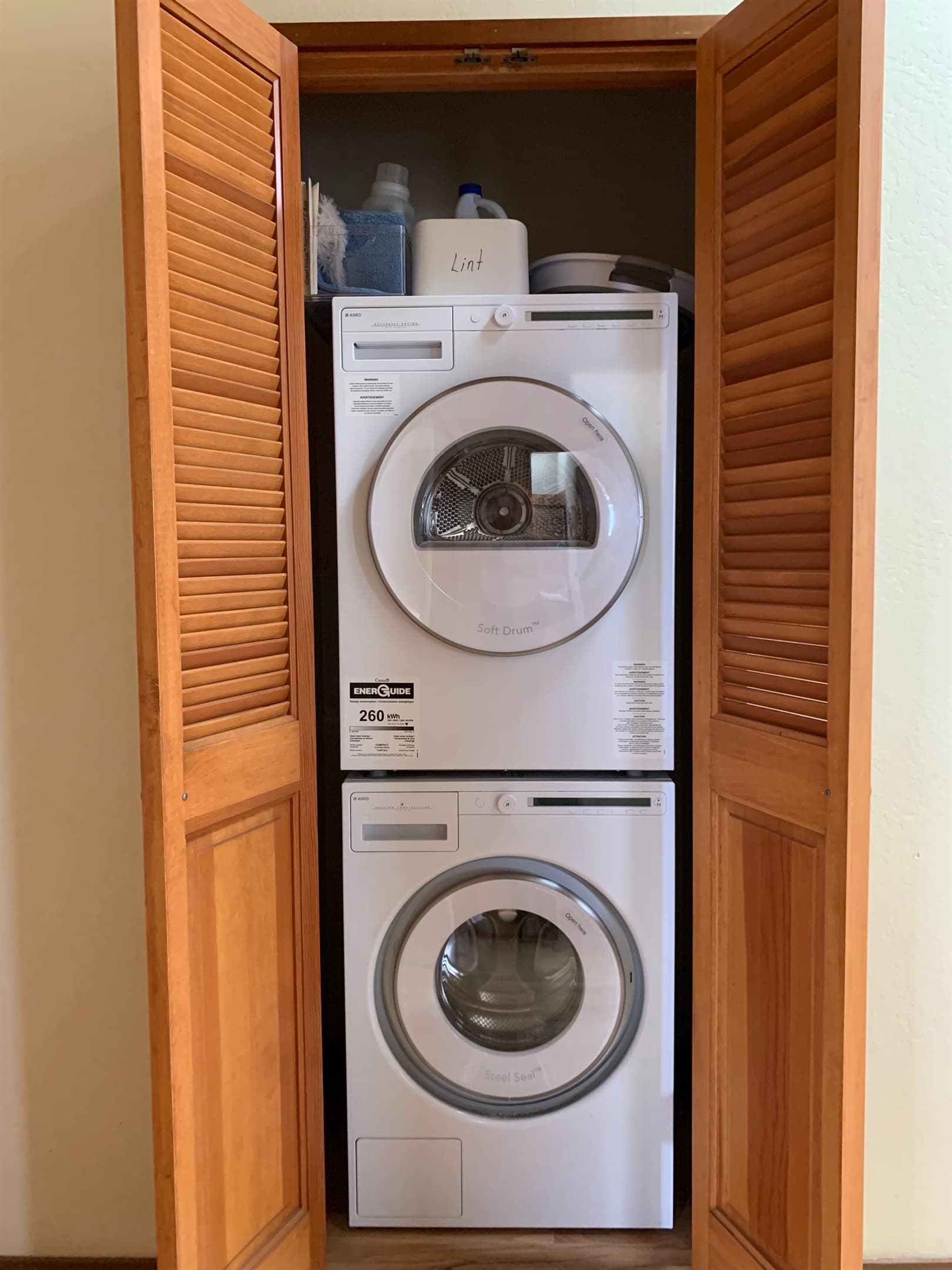 Small capacity interior laundry in hallway of house.