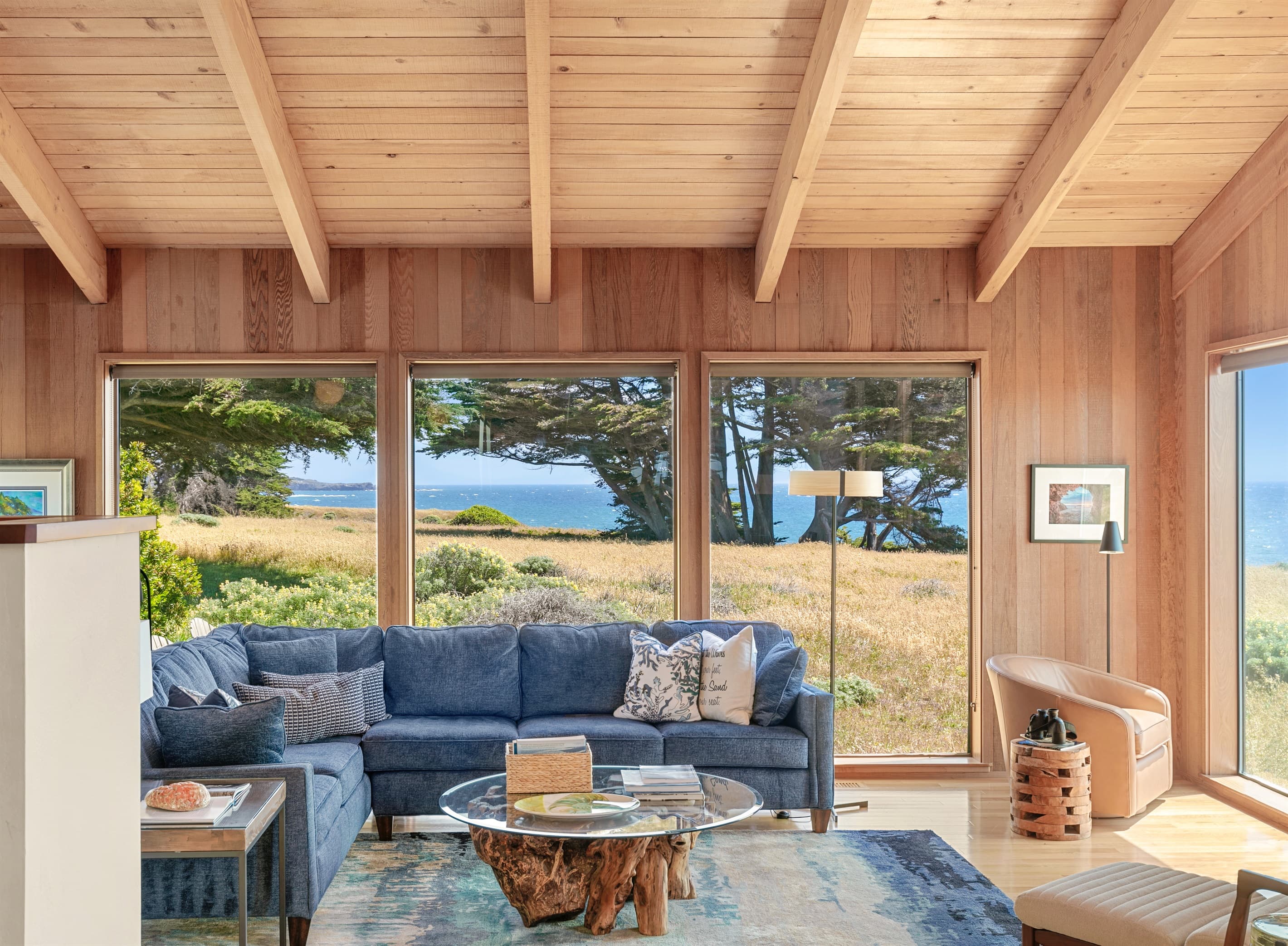 Breathtaking coastal views fill this elegant living space with natural light, where warm wood tones, plush seating, and nature-inspired design invite you to Experience nature at your doorstep in refined Sea Ranch comfort. 