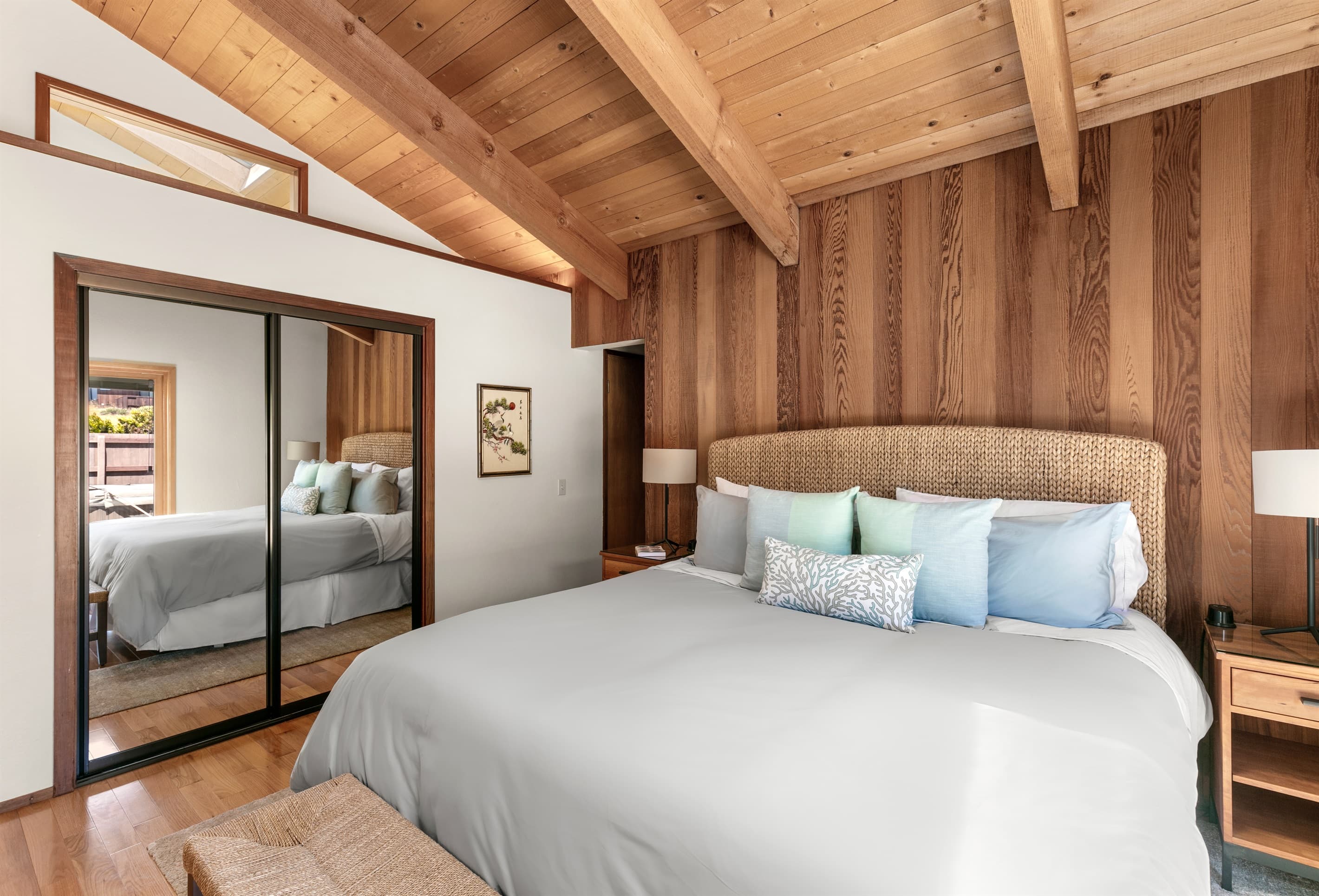Principal bedroom with ensuite and courtyard access, double mirrored closet, and skylight with blinds.
