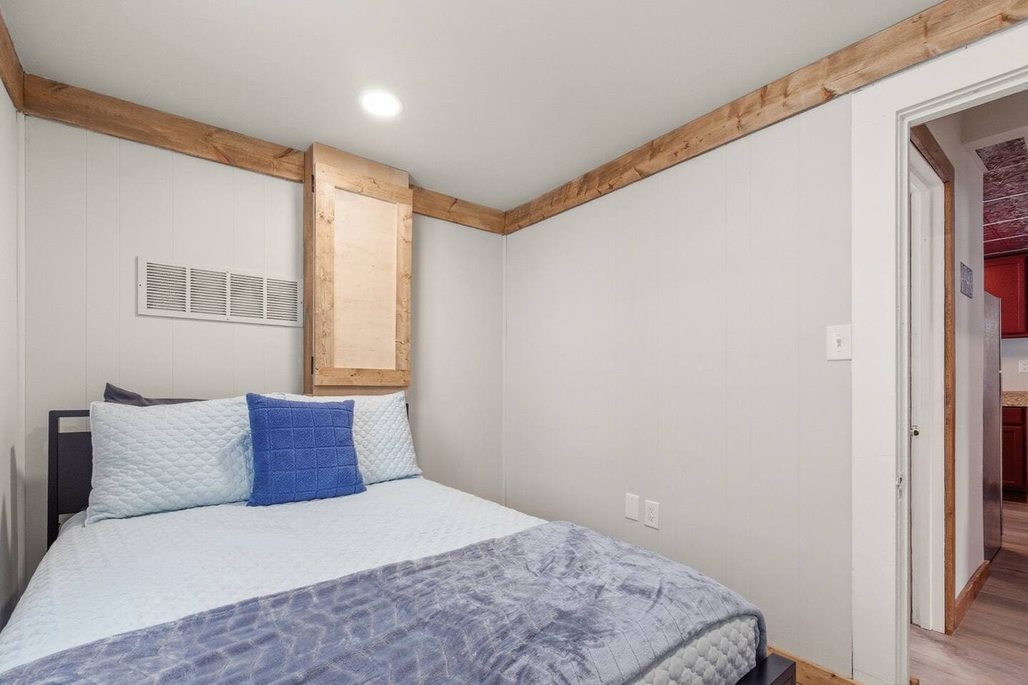 Cozy queen-sized bed in the downstairs bedroom. 