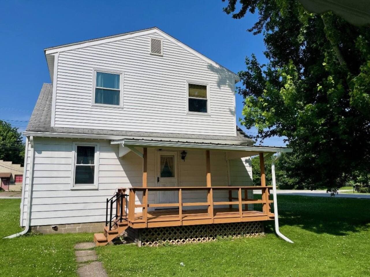 Relax on the outdoor porch as you enjoy the lovely yard