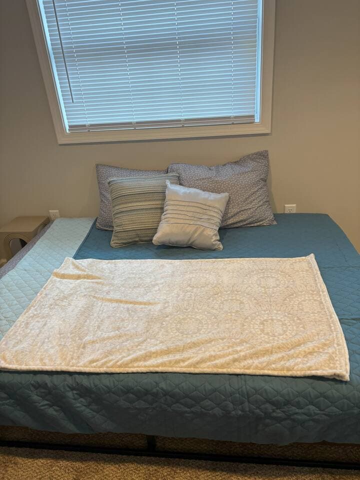 A full-size bed is set up on the floor, offering a simple and comfortable place to rest. Fresh linens and pillows are provided for a cozy night’s sleep.
