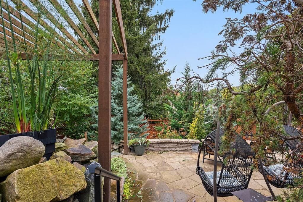 Patio, seating wall, hanging pod chairs and PA mountain stone patio and pond/ waterfall
