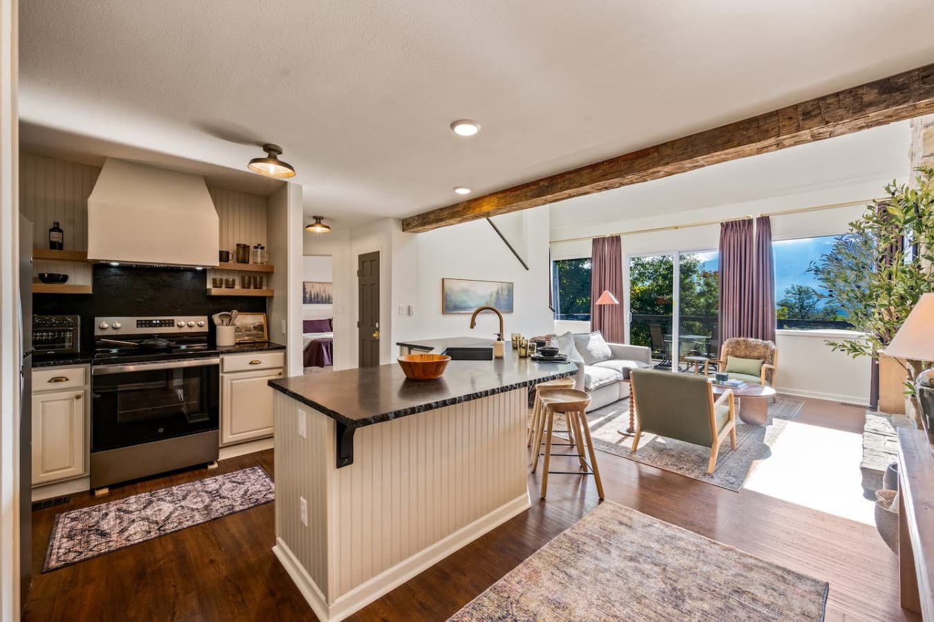 The open kitchen is filled with natural light and wide mountain views, blending modern design with rustic Smoky Mountain charm.