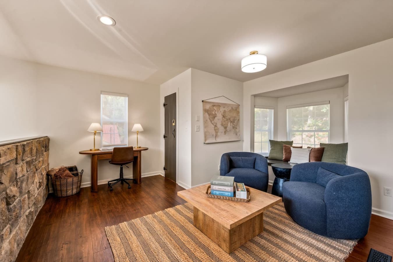 The second-floor living room feels like a private retreat, with cozy chairs tucked beneath slanted ceilings and mountain light streaming in.