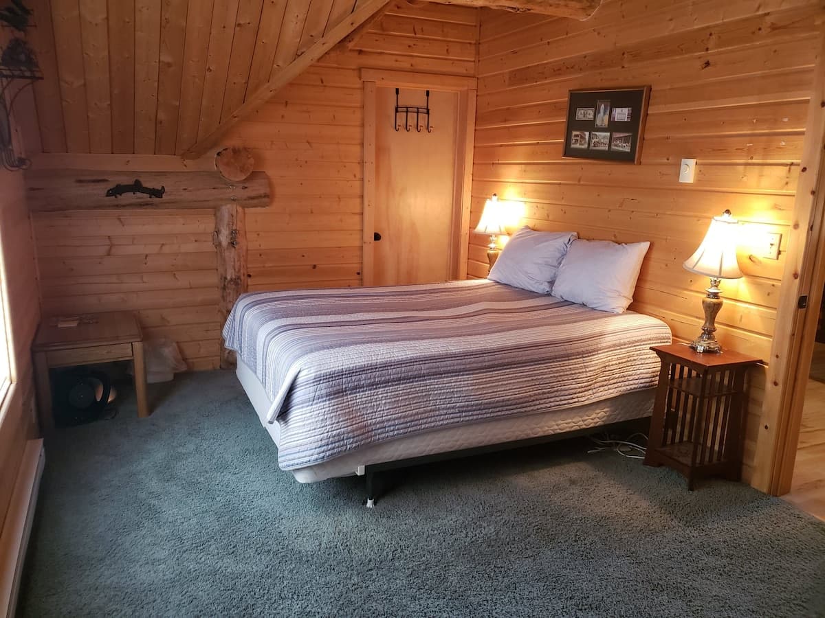 Bedroom 4: provides a comfortable queen bed and beautiful forest views.