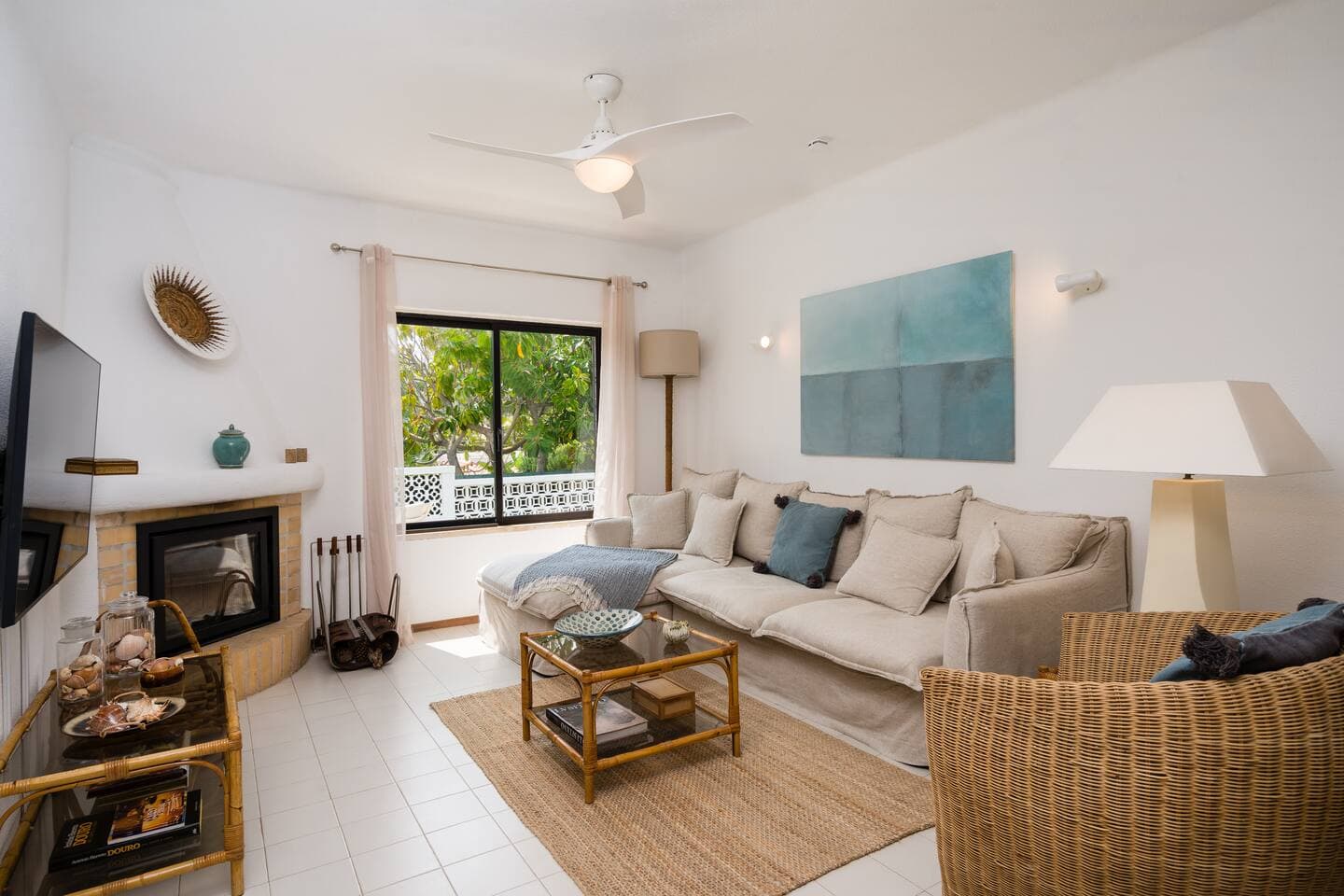 Bright, open living space, with smart TV and a big linen couch 
