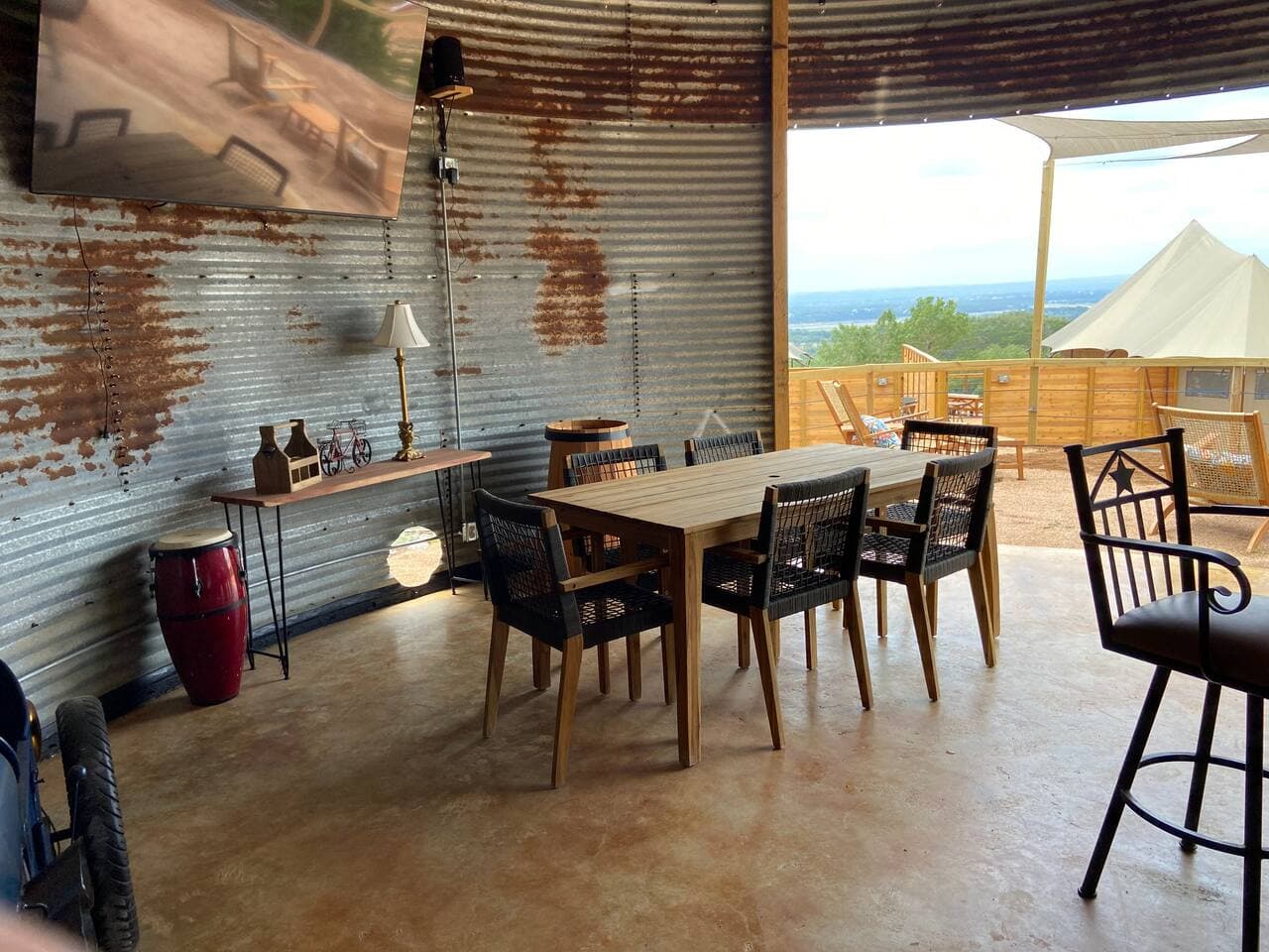 Community area with dining table, bar, 75' TV, gas grill and hot tub.