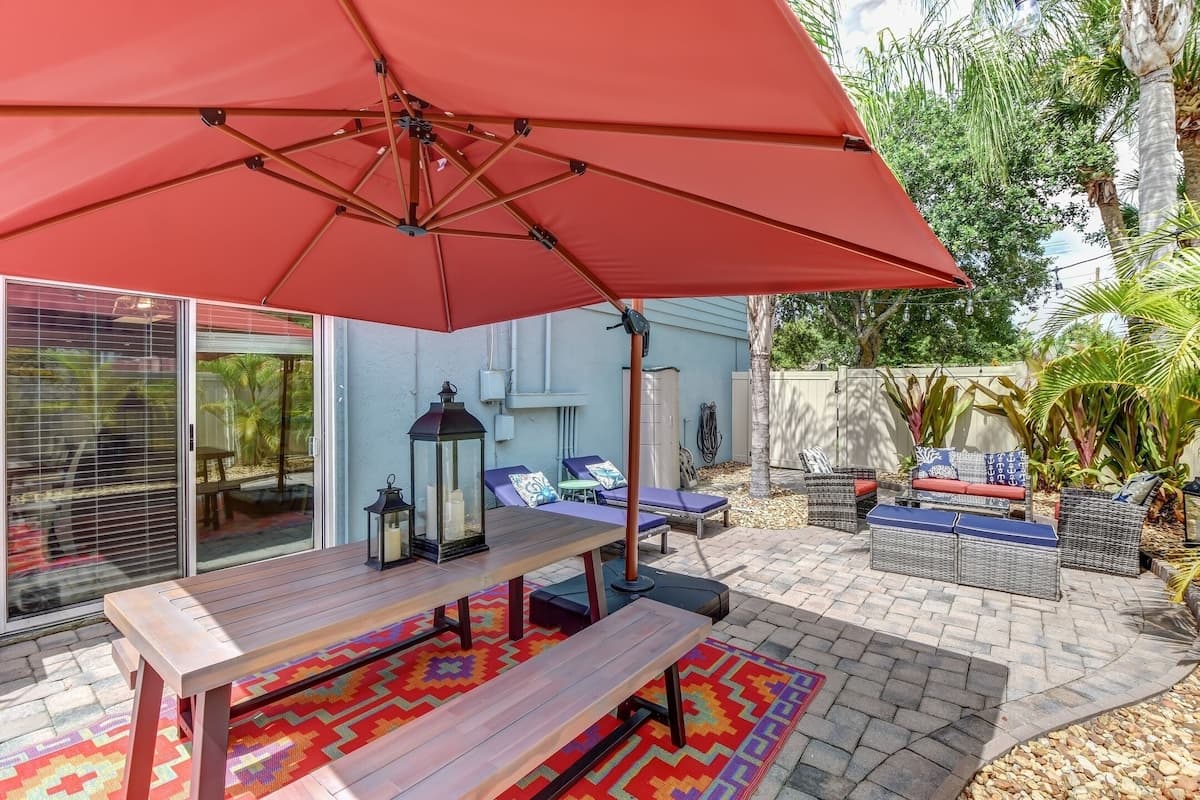 Outdoor Private Fenced String-Lit Yard with Dining Table and Sun Loungers