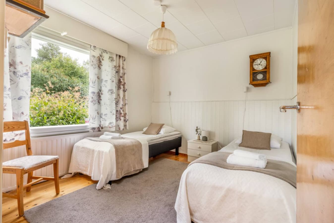 Wake up to natural light and a charming view of greenery through the window. This serene twin bedroom offers plush bedding, soft neutral tones, and all the comforts you need for a restful stay.