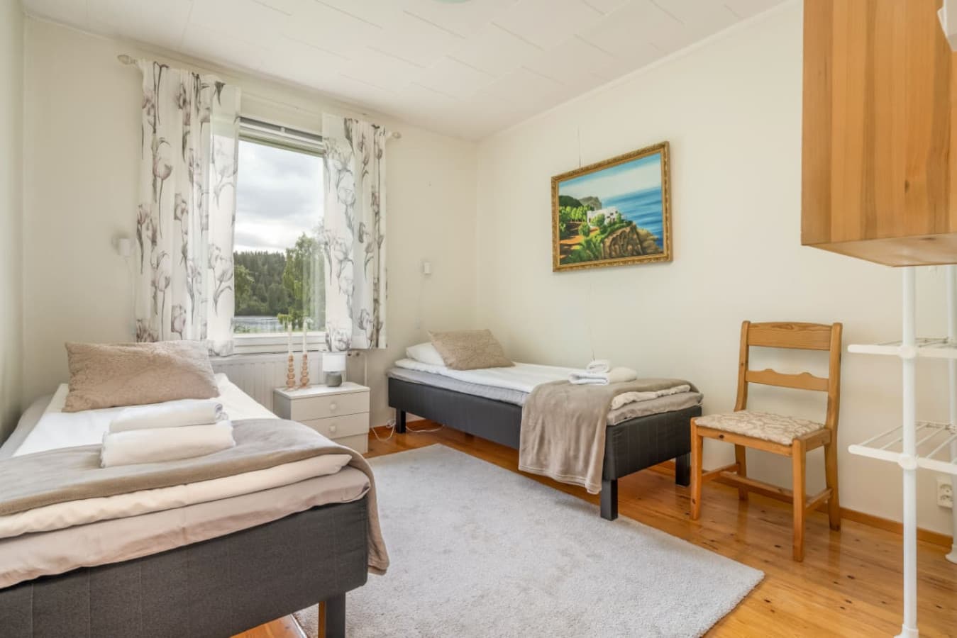 Enjoy tranquil mornings in this bright and airy twin bedroom, featuring cozy beds.