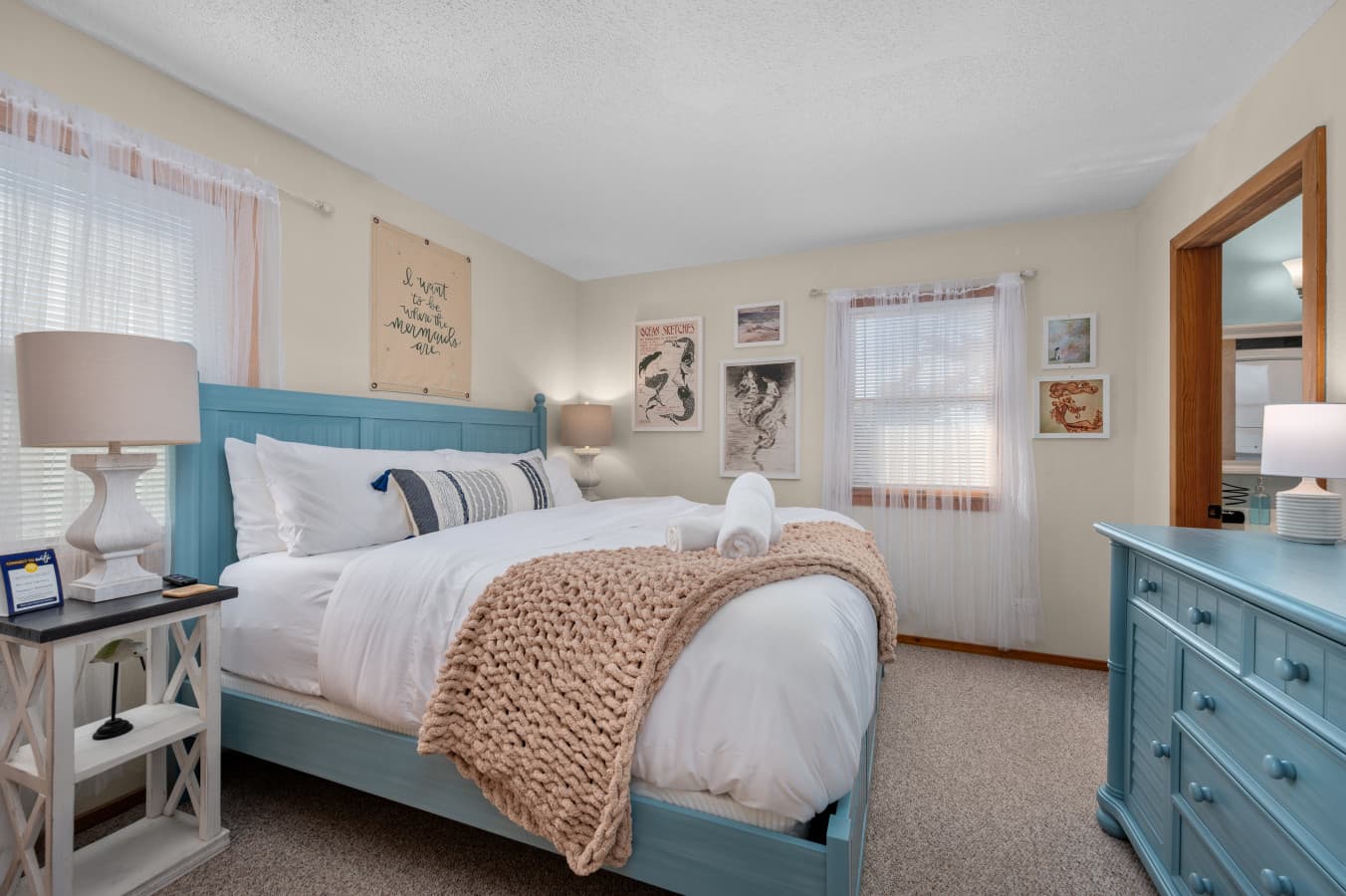Inviting bedroom w/ layered bedding, soft textures & calming neutral tones