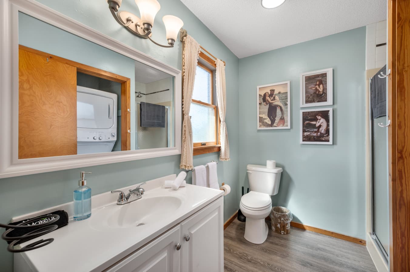 Full bathroom w/ double sink vanity, mirror & soft blue walls