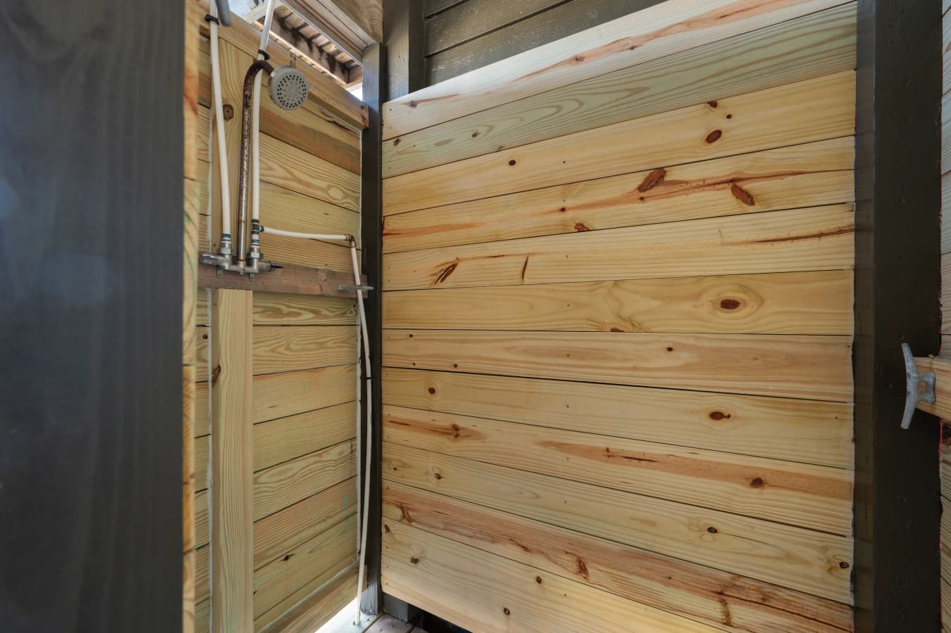 Rustic outdoor shower w/ wood walls for a refreshing rinse after the beach