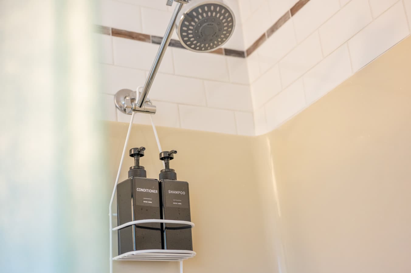 Shower w/ tiled walls, rainfall head & mounted bath essentials