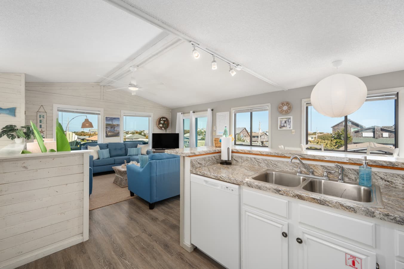Open kitchen w/ island seating flowing into a bright living area filled w/ light