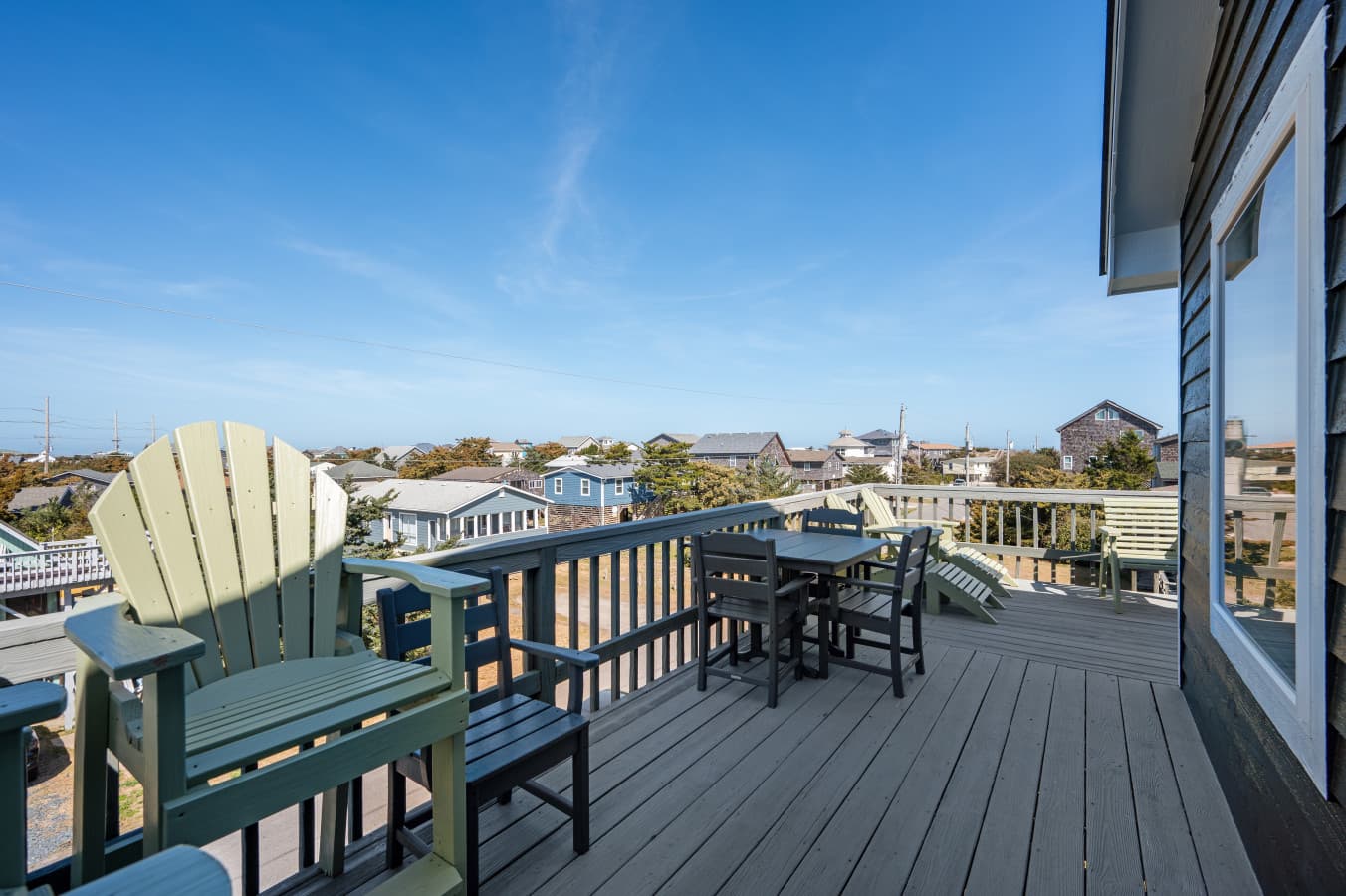 Upper deck w/ Adirondack chairs, bistro table & open views across the neighborhood rooftops.