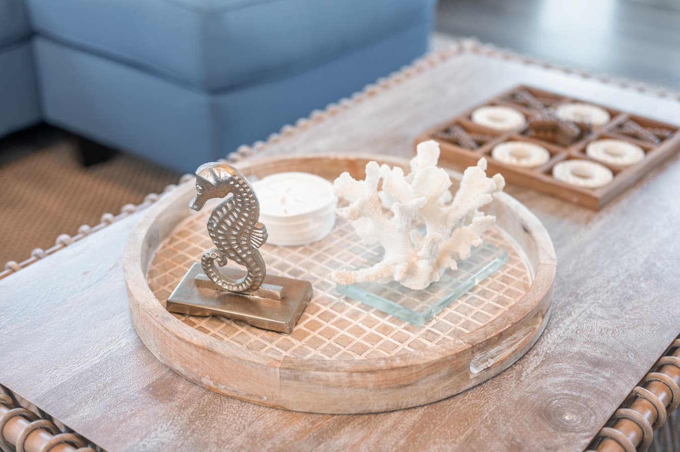 Coffee table detail w/ a coastal tray, coral accents & a wooden tic-tac-toe set for slow mornings.