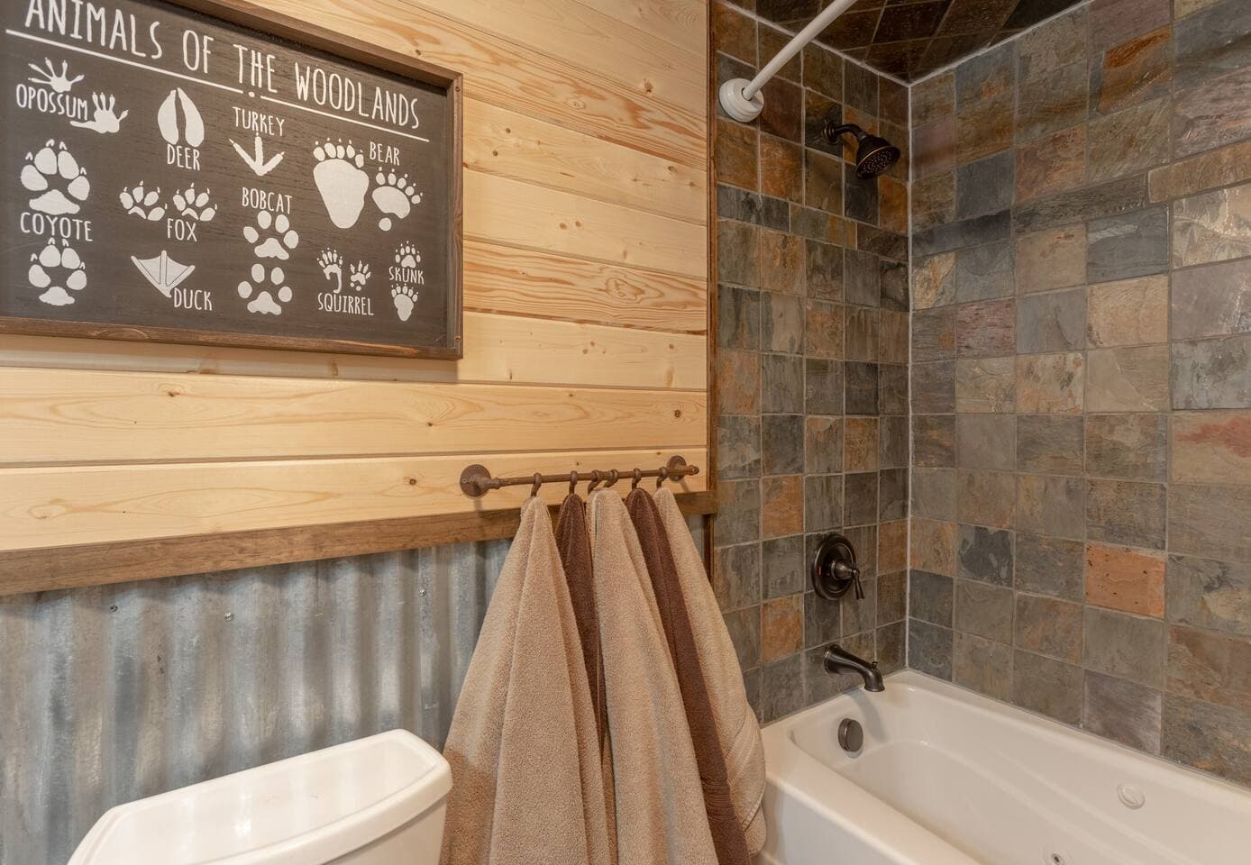 Bathroom 1: This bathroom is adorned in slate tiles giving it a beautiful rustic feel.  Sit back and relax in this jetted tub and shower combo.