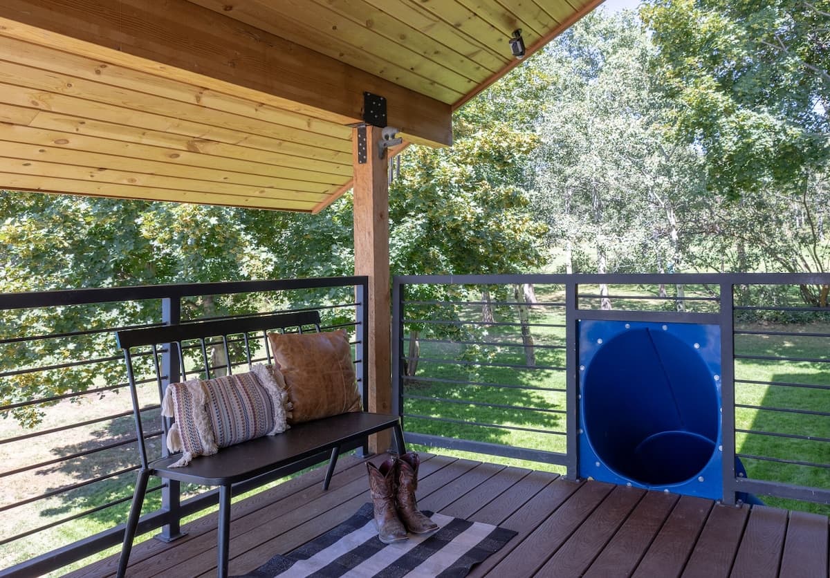 Large deck with multiple seating options and a slide for kids