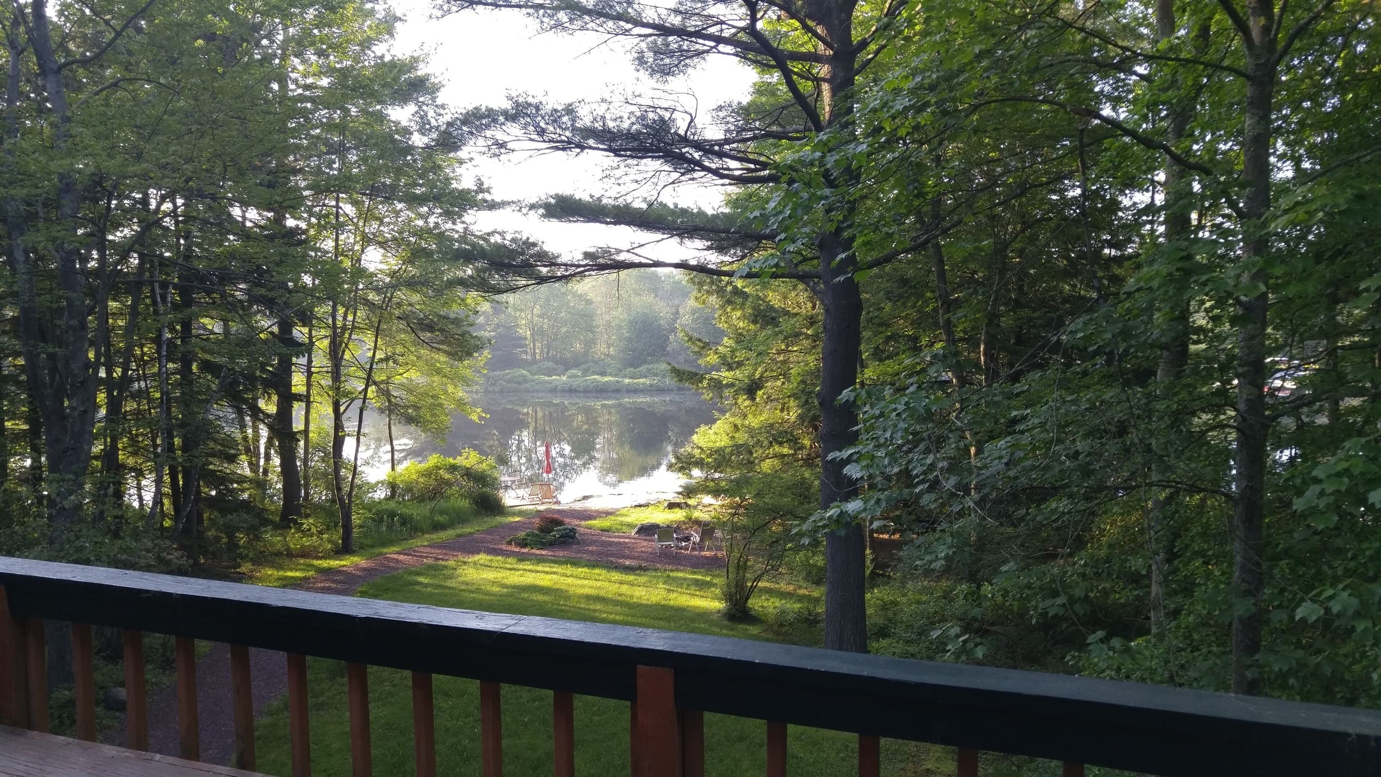 View of Lake Naomi, private beach, dock, and fire pit from upper deck
