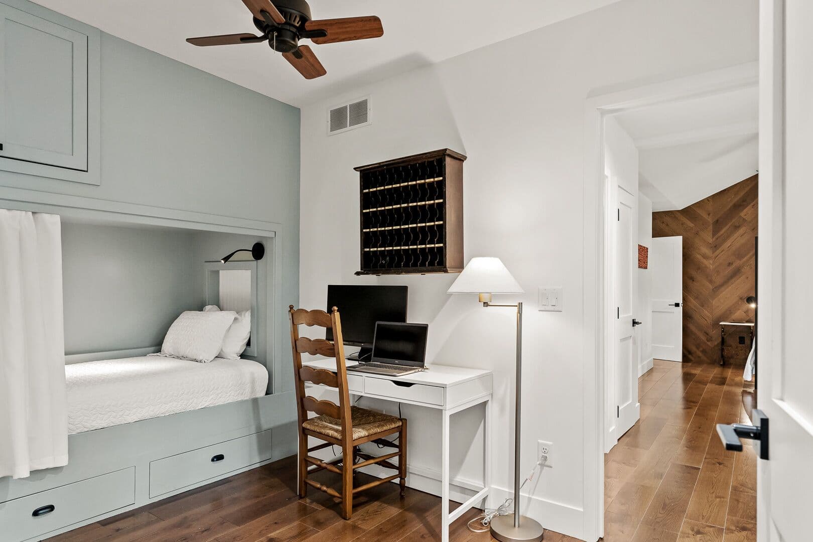 Office with laptop and curtained alcove bed