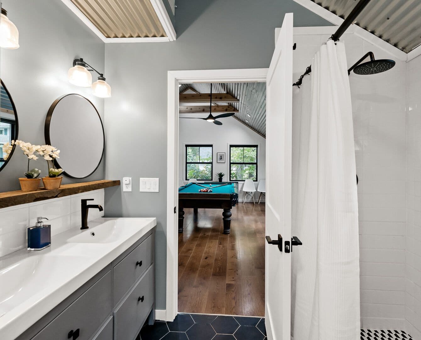 Large shower with rainshower head and double vanity in the guest house bathroom.