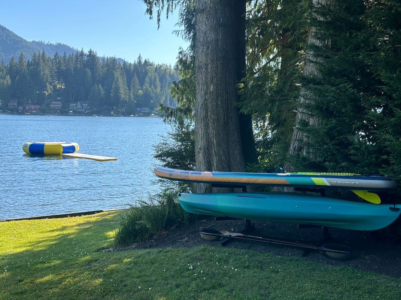 Two kayaks, two paddleboards, water trampoline, and a foam water mat — all ready for fun on the lake.