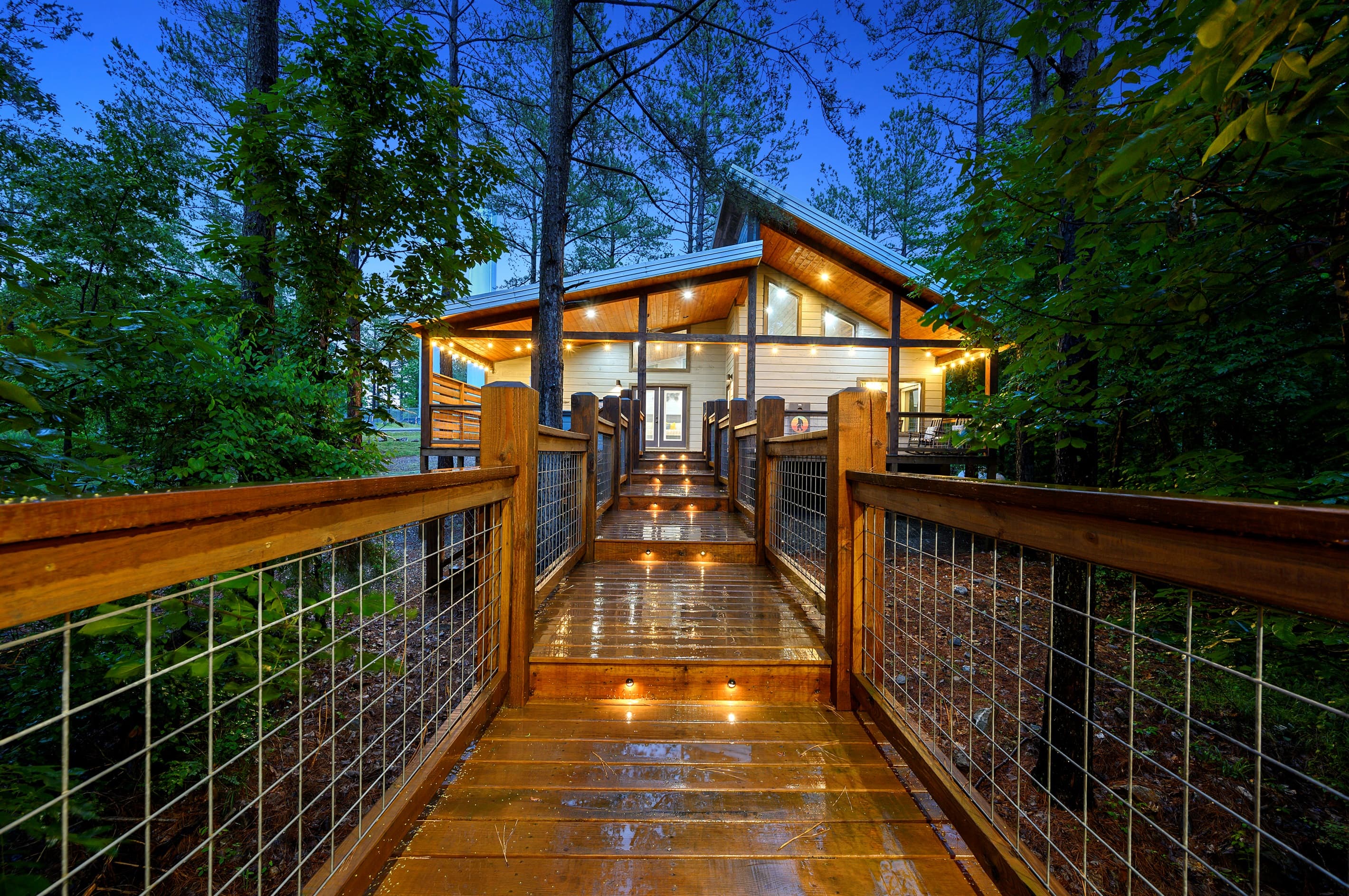 View from the gazebo showcasing the expansive back porch, beautifully lit with charming string lights—perfect for relaxing