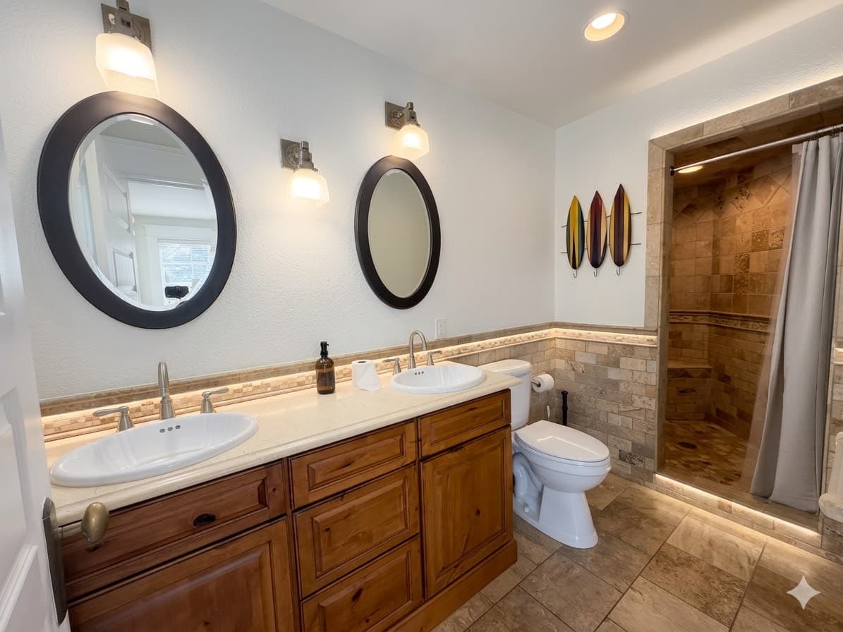 Bathroom 2 — Coastal-Style Ensuite with Dual Wooden Vanity, Round Mirrors & Stone Walk-In Shower | The Mark Twain Estate, Outer Banks