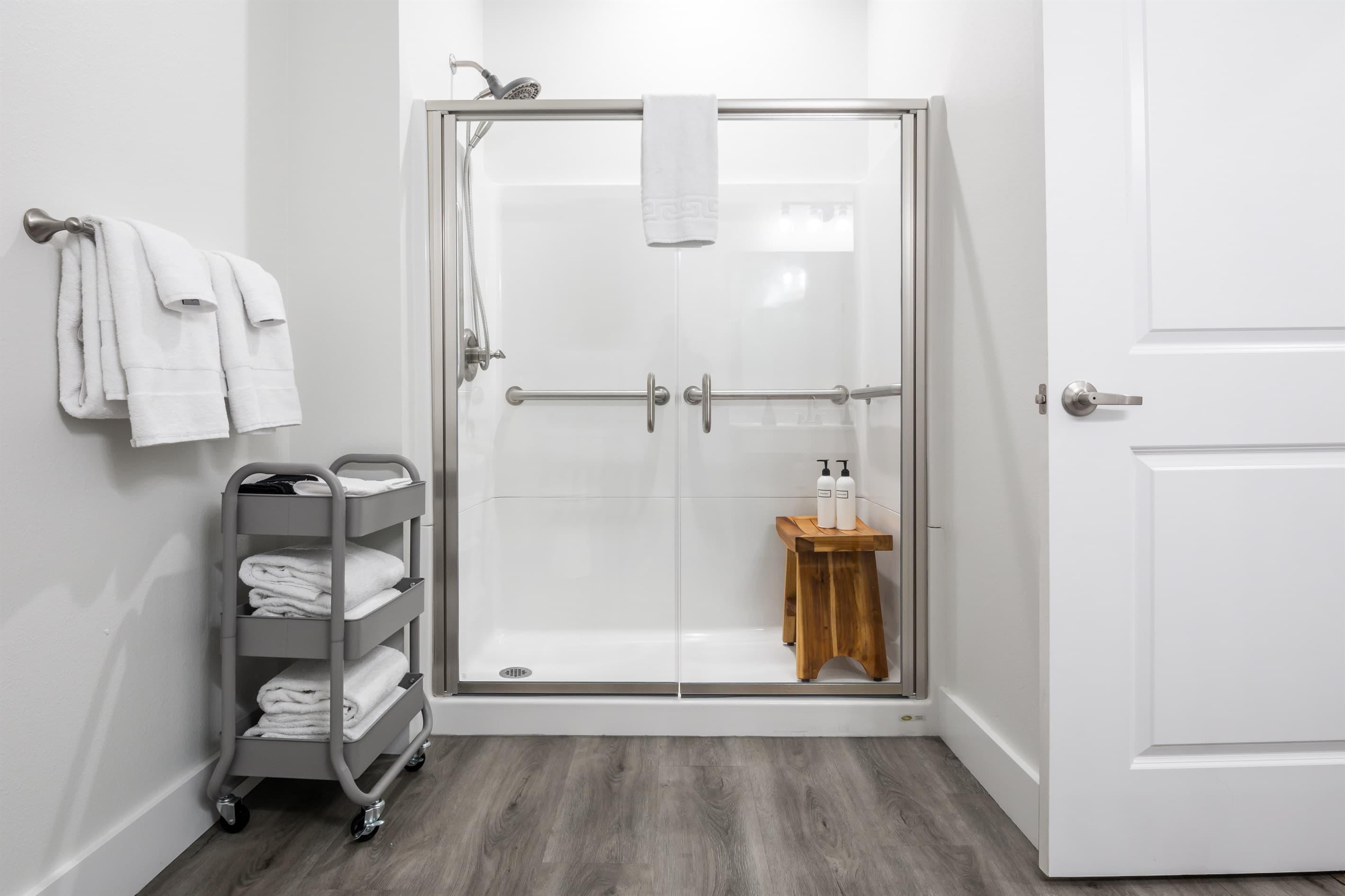 Main level suite #1 with accessible bathroom that has low curb shower with grab bars with seat and hand held shower head