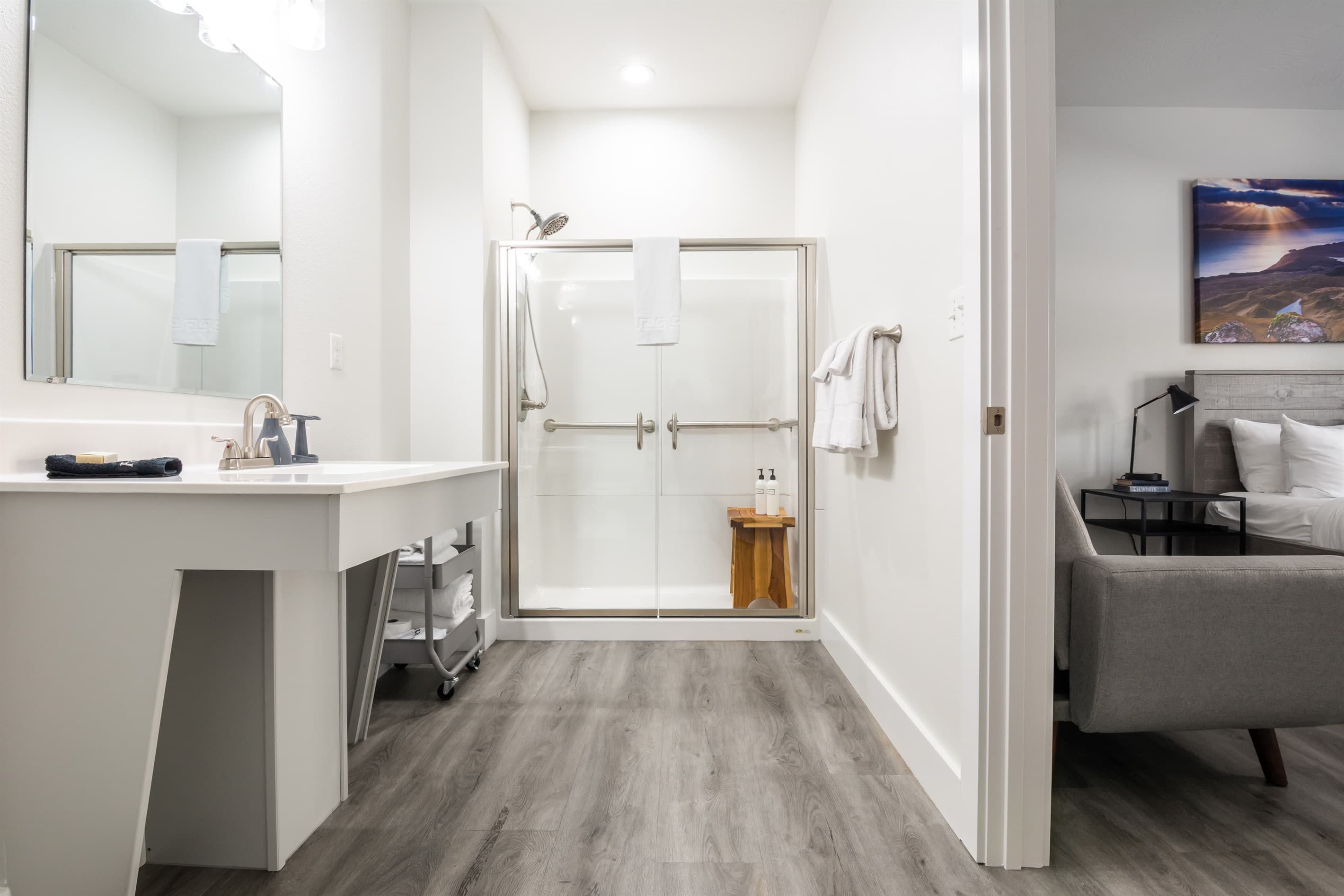 Main level suite #2 with accessible bathroom with low curb shower that has grab bars, seating, and hand held shower head