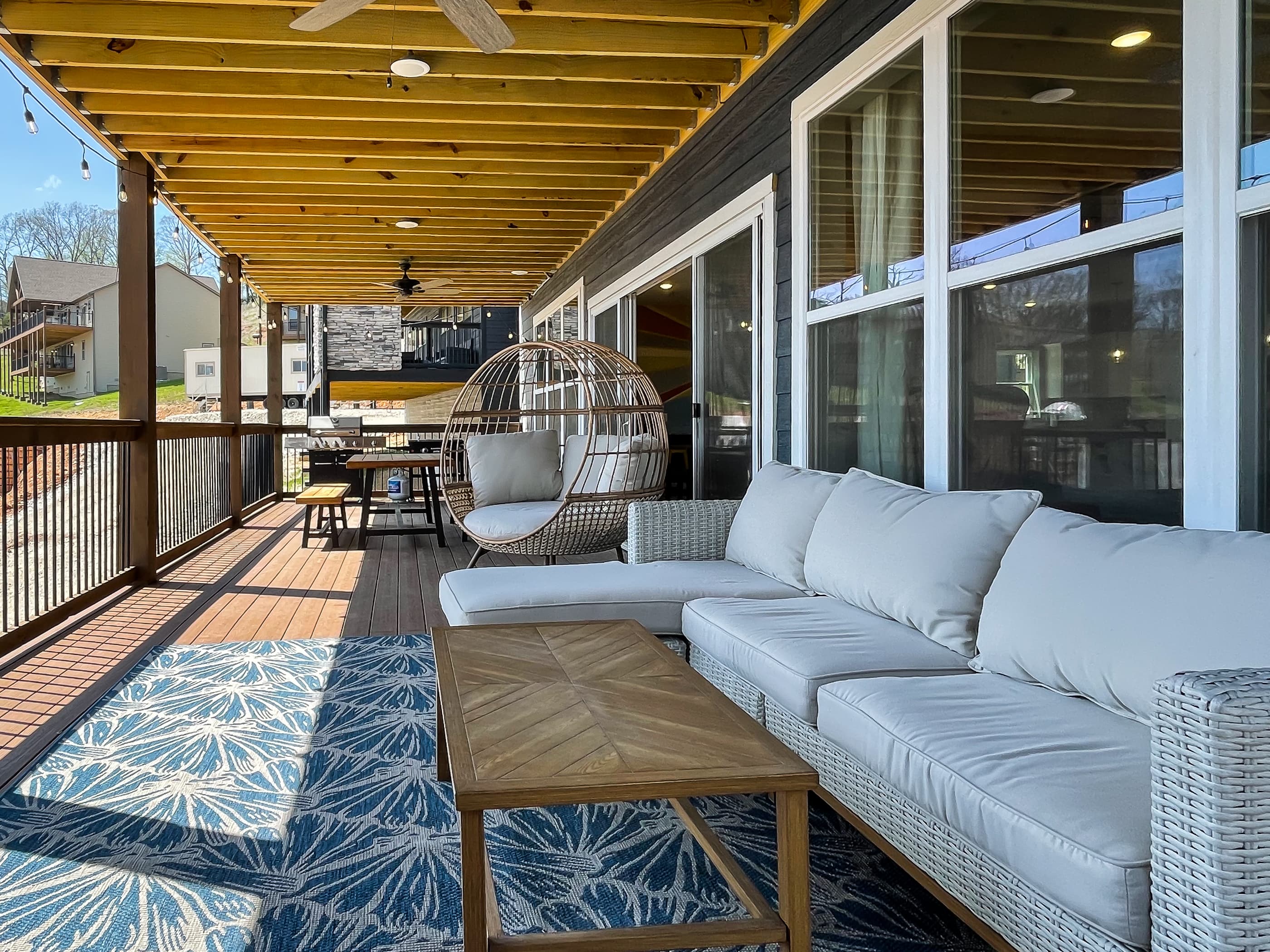 Main level deck with gas fireplace, comfy seating, picnic table, grills, and lake view