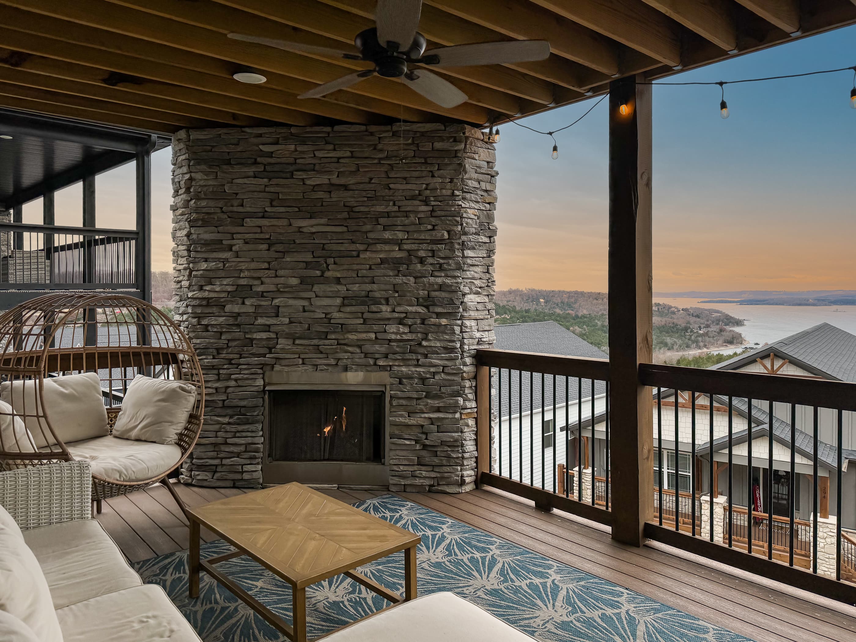 Main level deck with gas fireplace and sectional couch for lake viewing