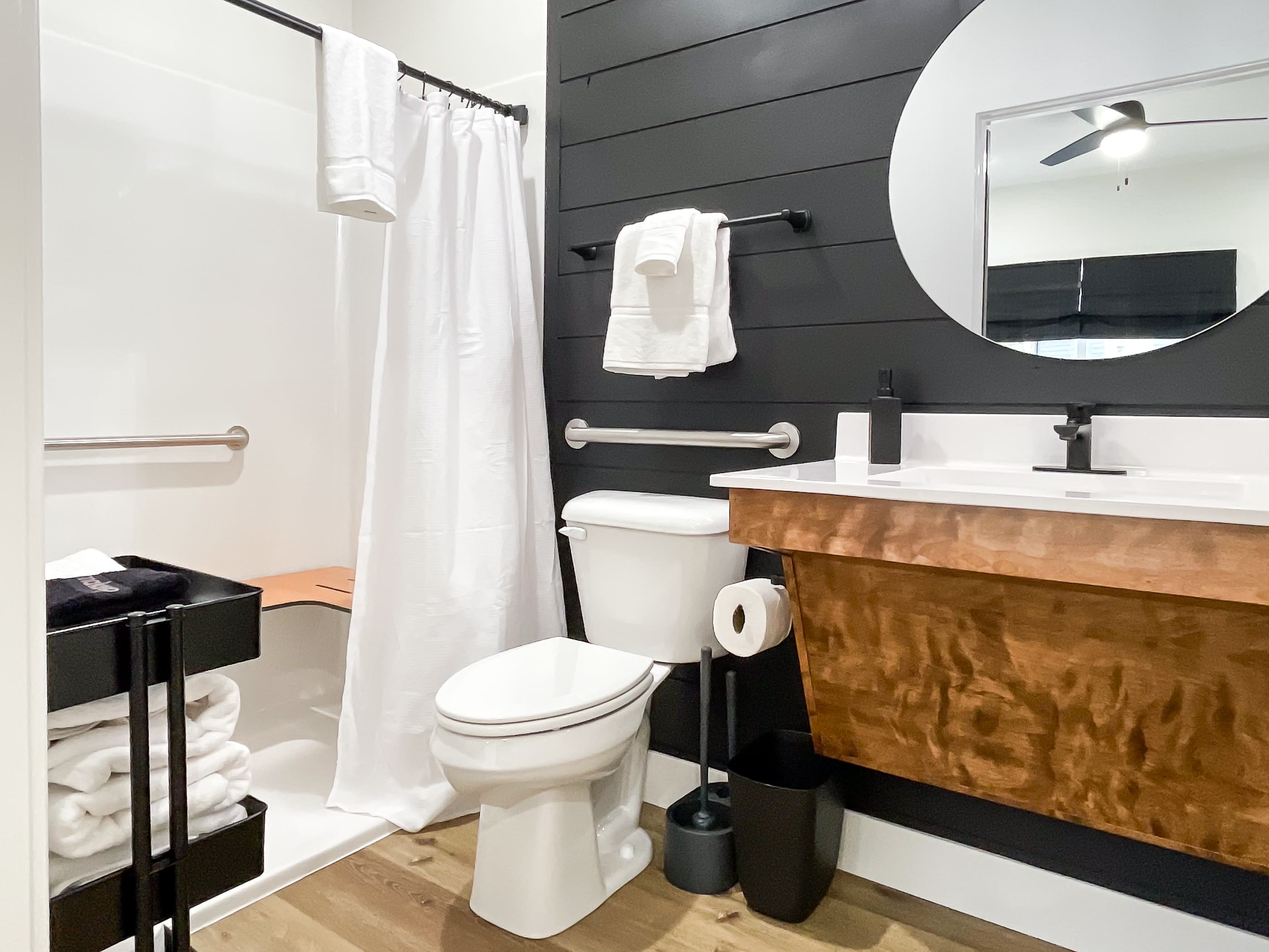 Bedroom 1: En-suite bathroom low curb shower with grab bars/handheld shower head with seat available, toilet with grab bars, and vanity