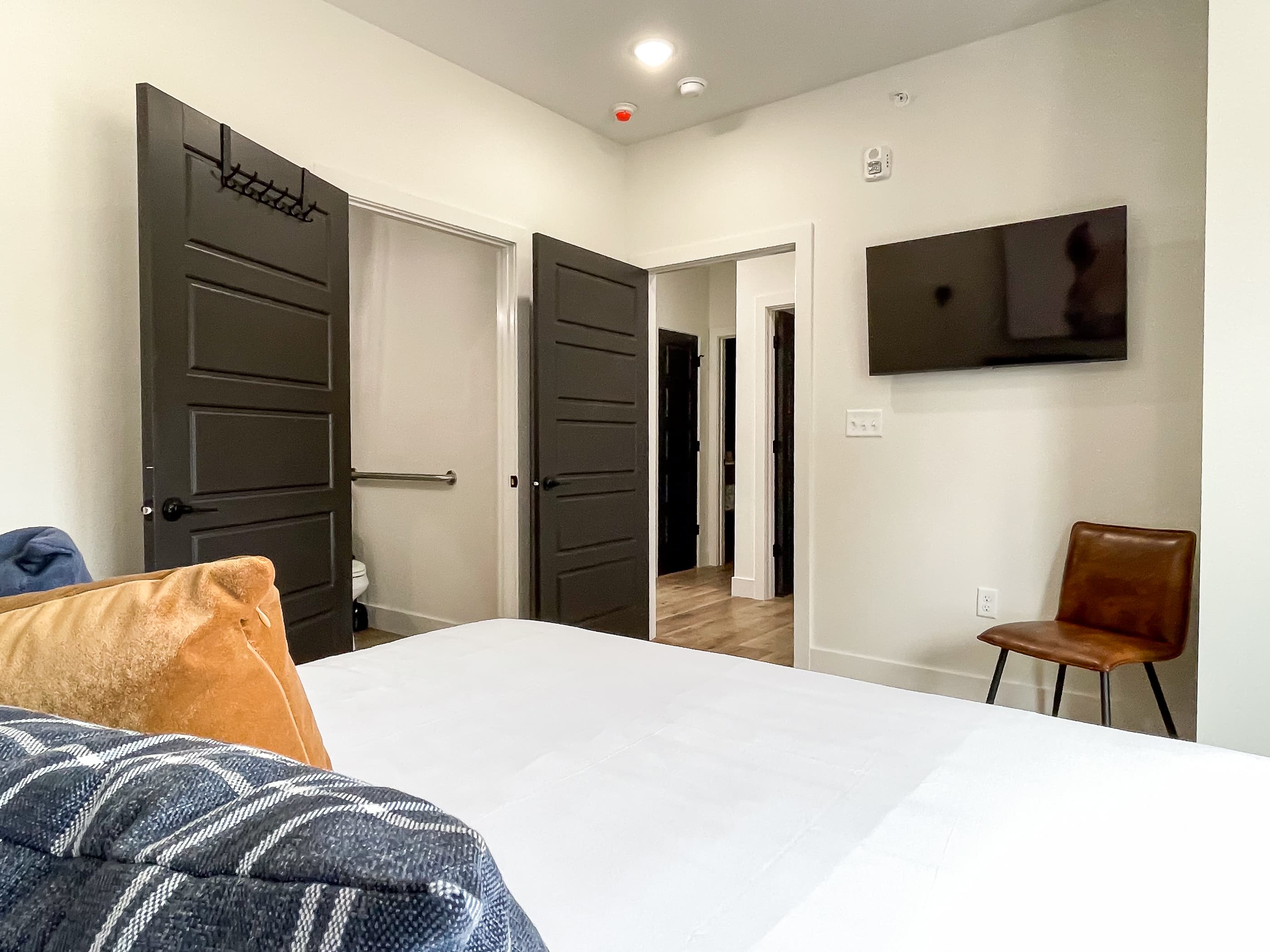 Spacious main level bedroom with tv, extra seating, and ensuite bathroom