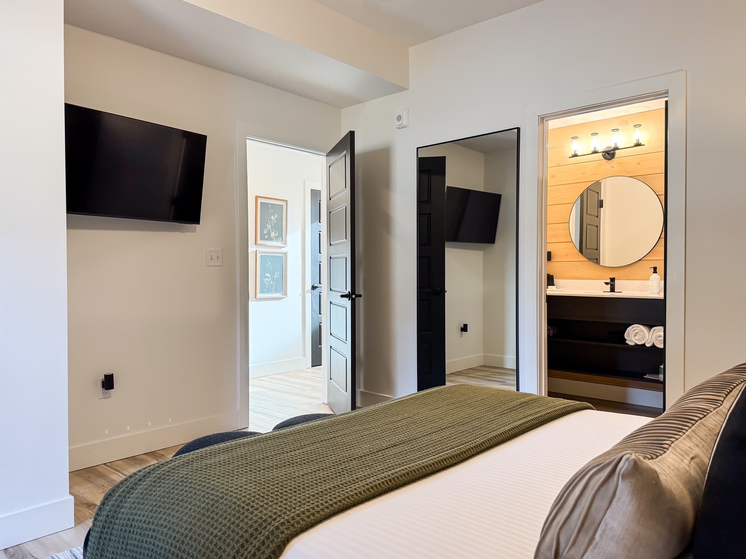 Bedroom 2: Tv across the bed, full length mirror, and entrance to the en-suite bathroom