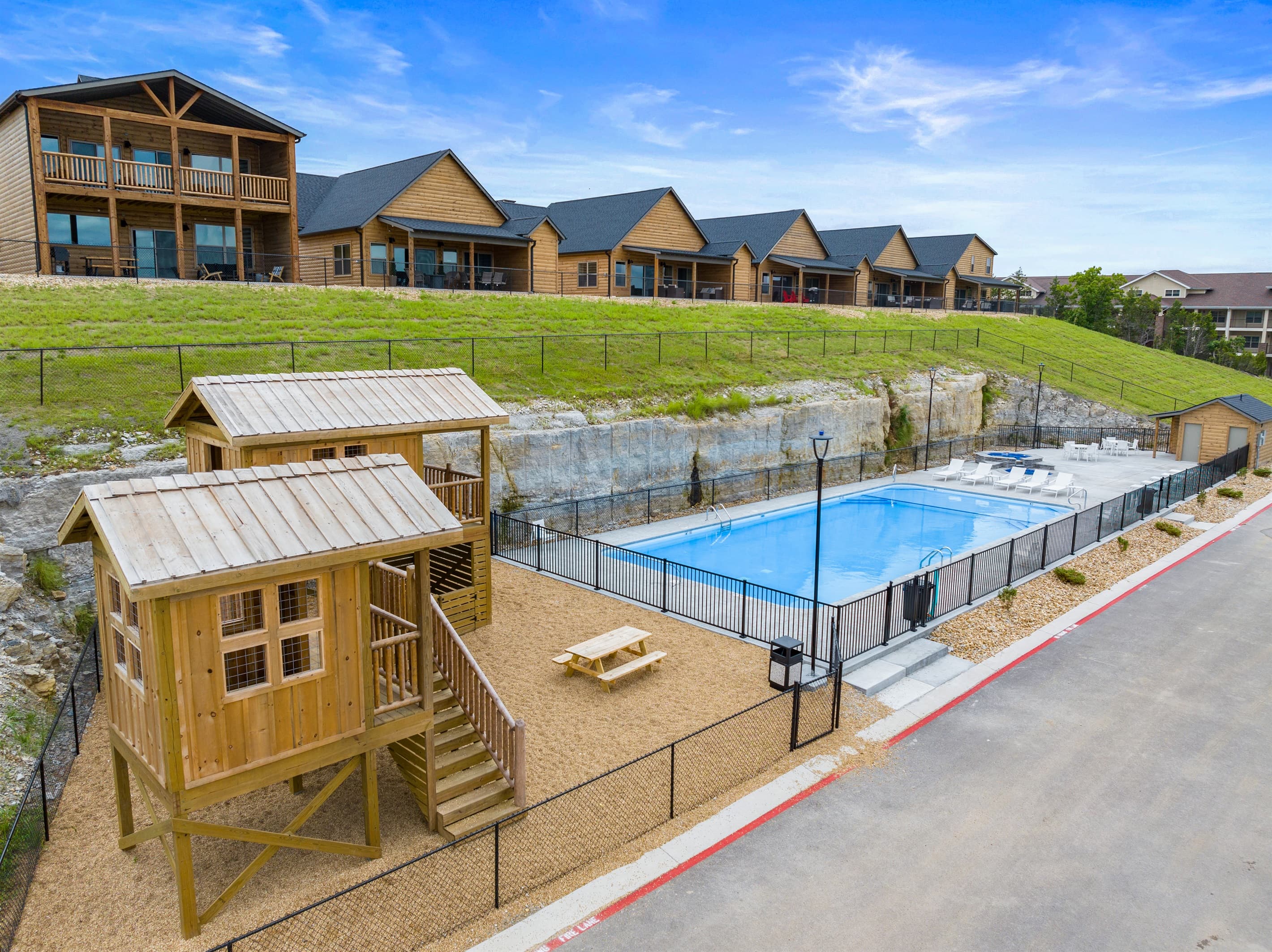Play area and kiddie pool with lounge chairs next to each other