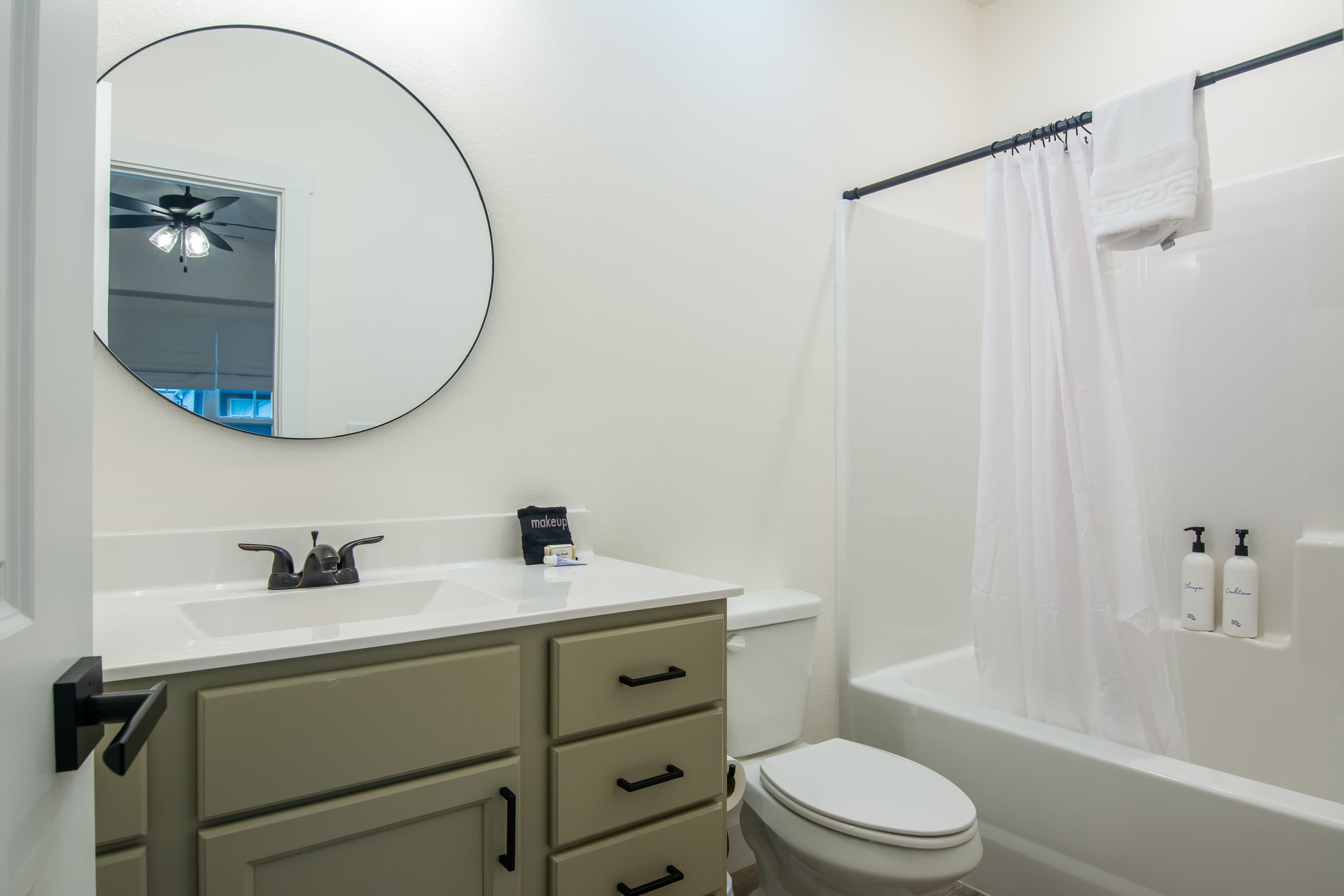 Bedroom 2 En-suite bathroom with a tub shower, toilet, and vanity