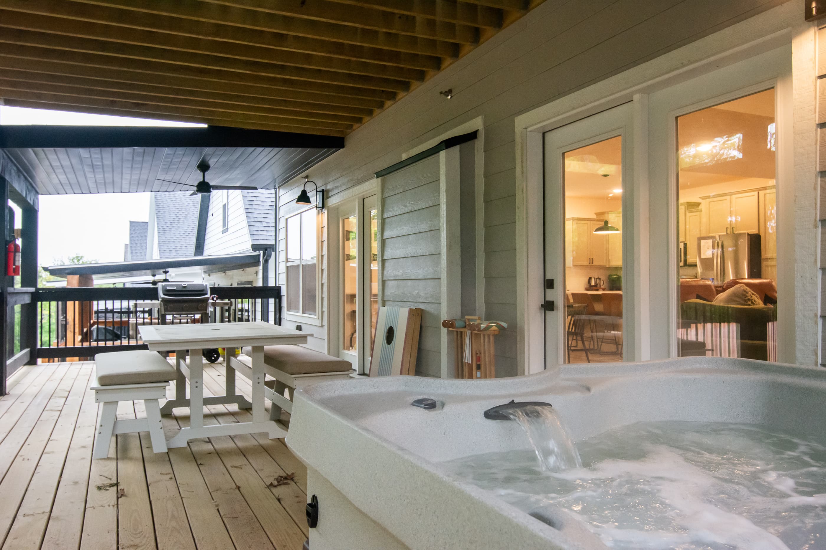 Hot tub, dining table, corn hole, and grill