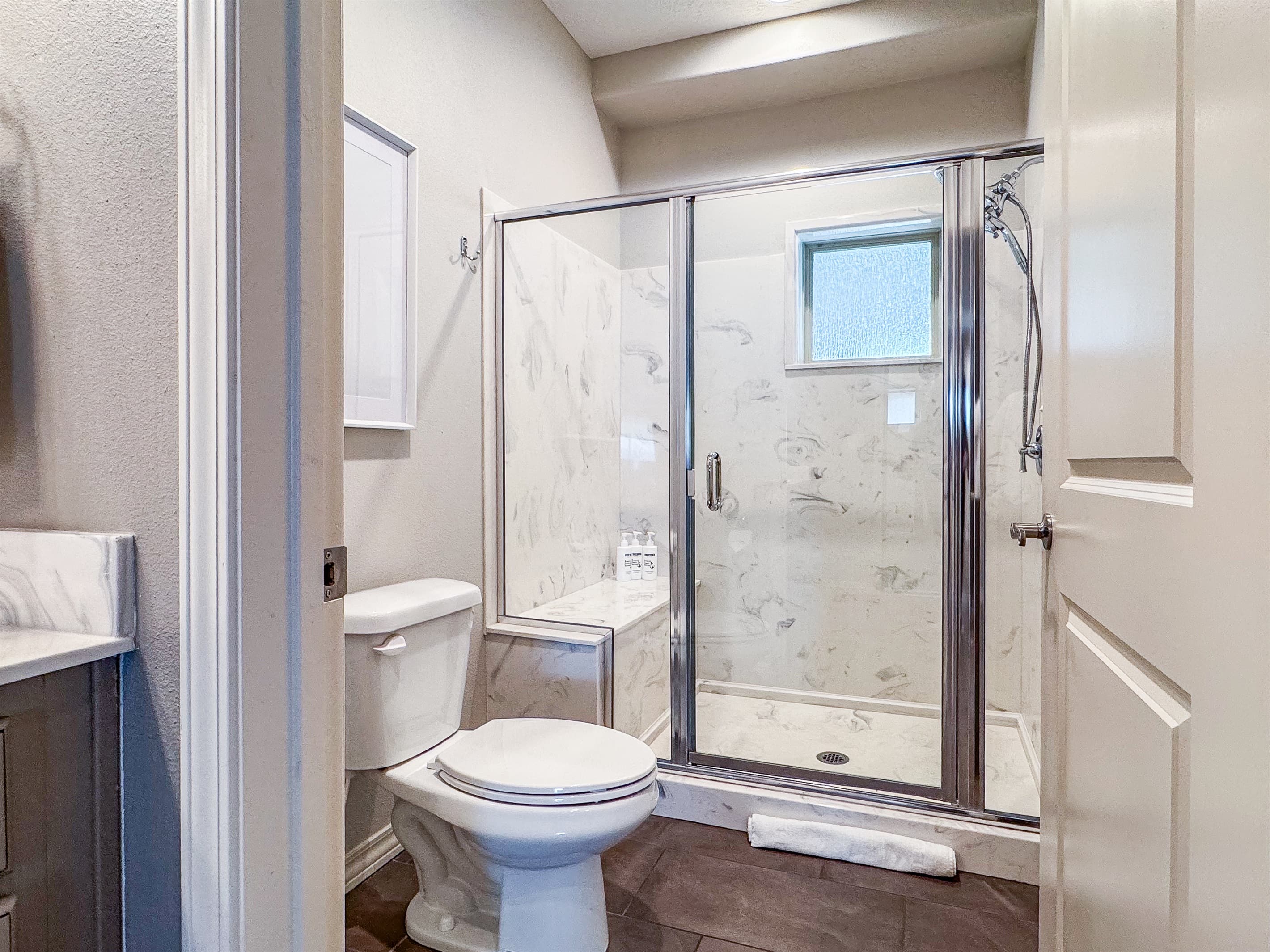 Bedroom 2 en-suite bathroom with toilet and talk in shower with hand held shower head 