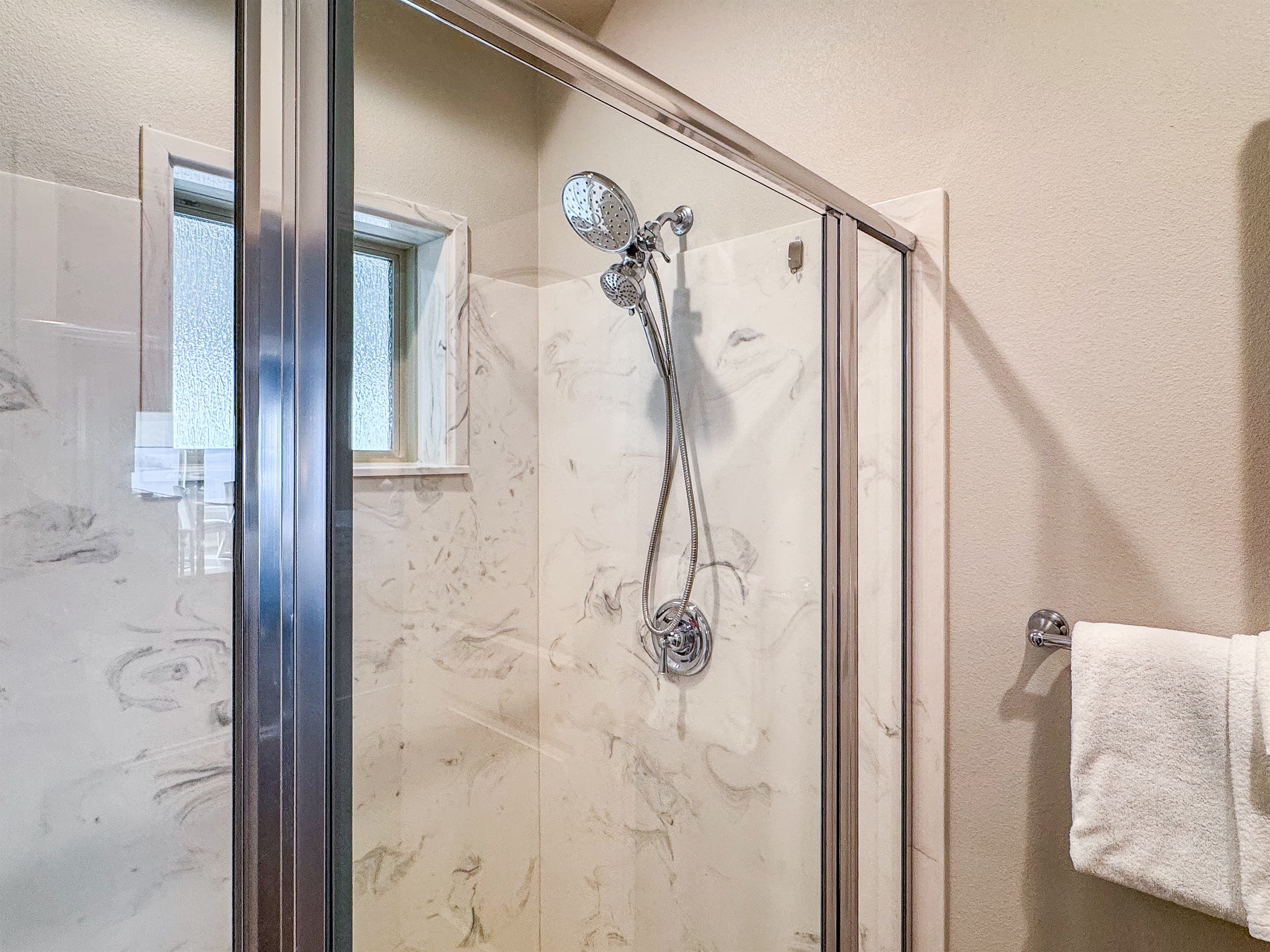 Bedroom 2 en-suite with handheld shower head and towel rack close by