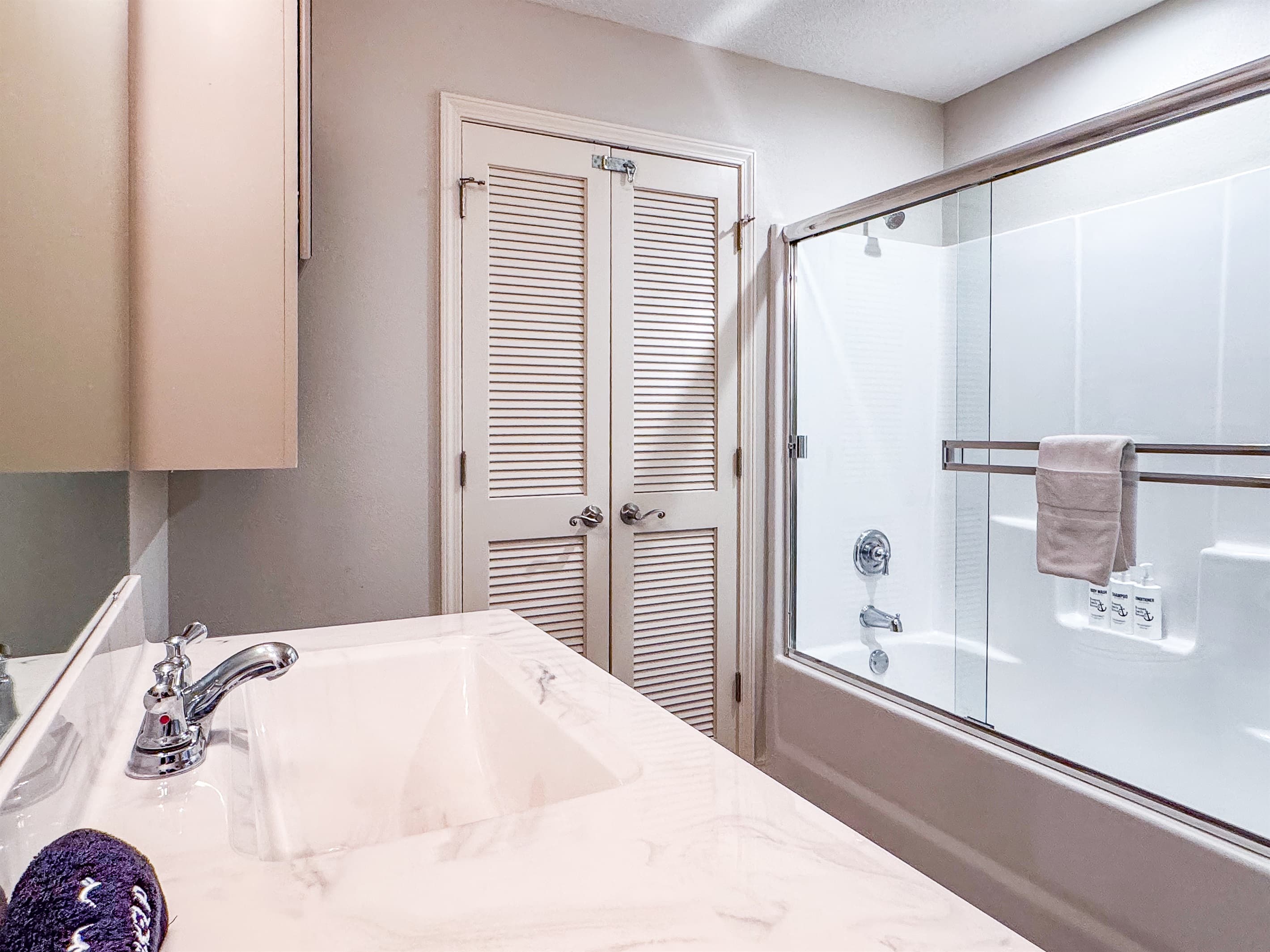Upper level bathroom with a tub/shower combo and double vanity sinks