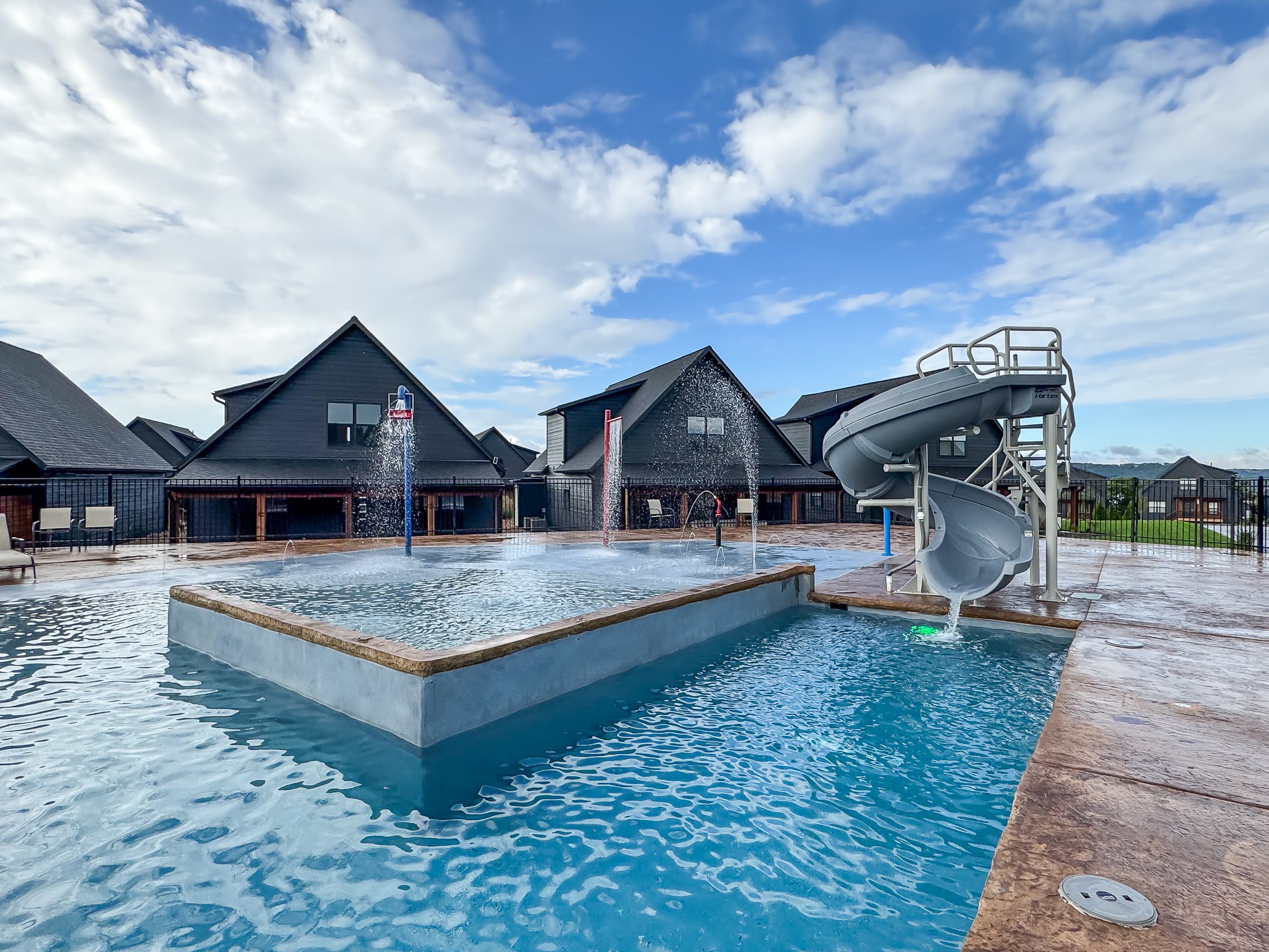 Neighborhood outdoor pool with slide and sloped "beach like" entry