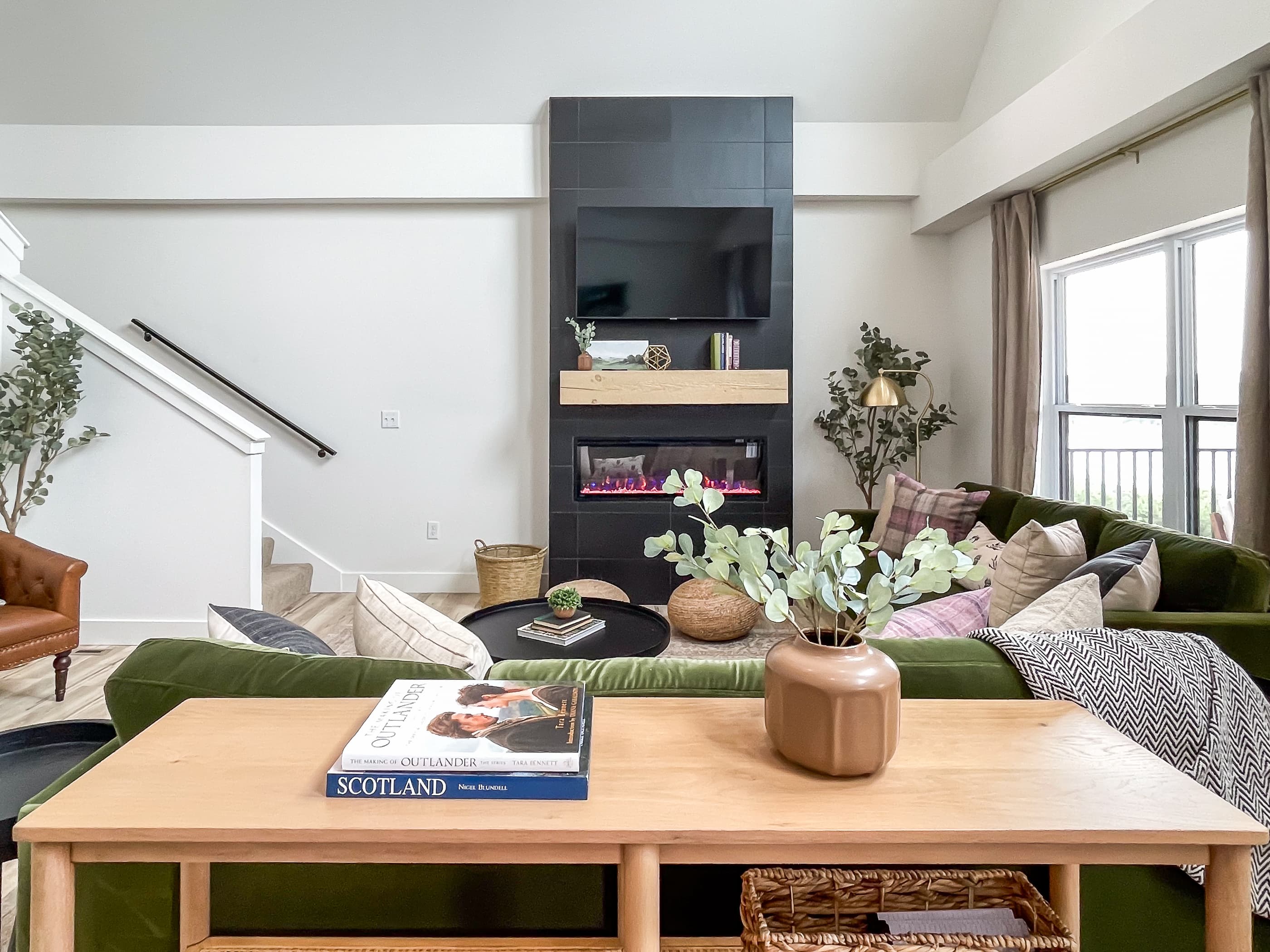 Cuddle up on the green velvet couches with the electric fireplace and TV