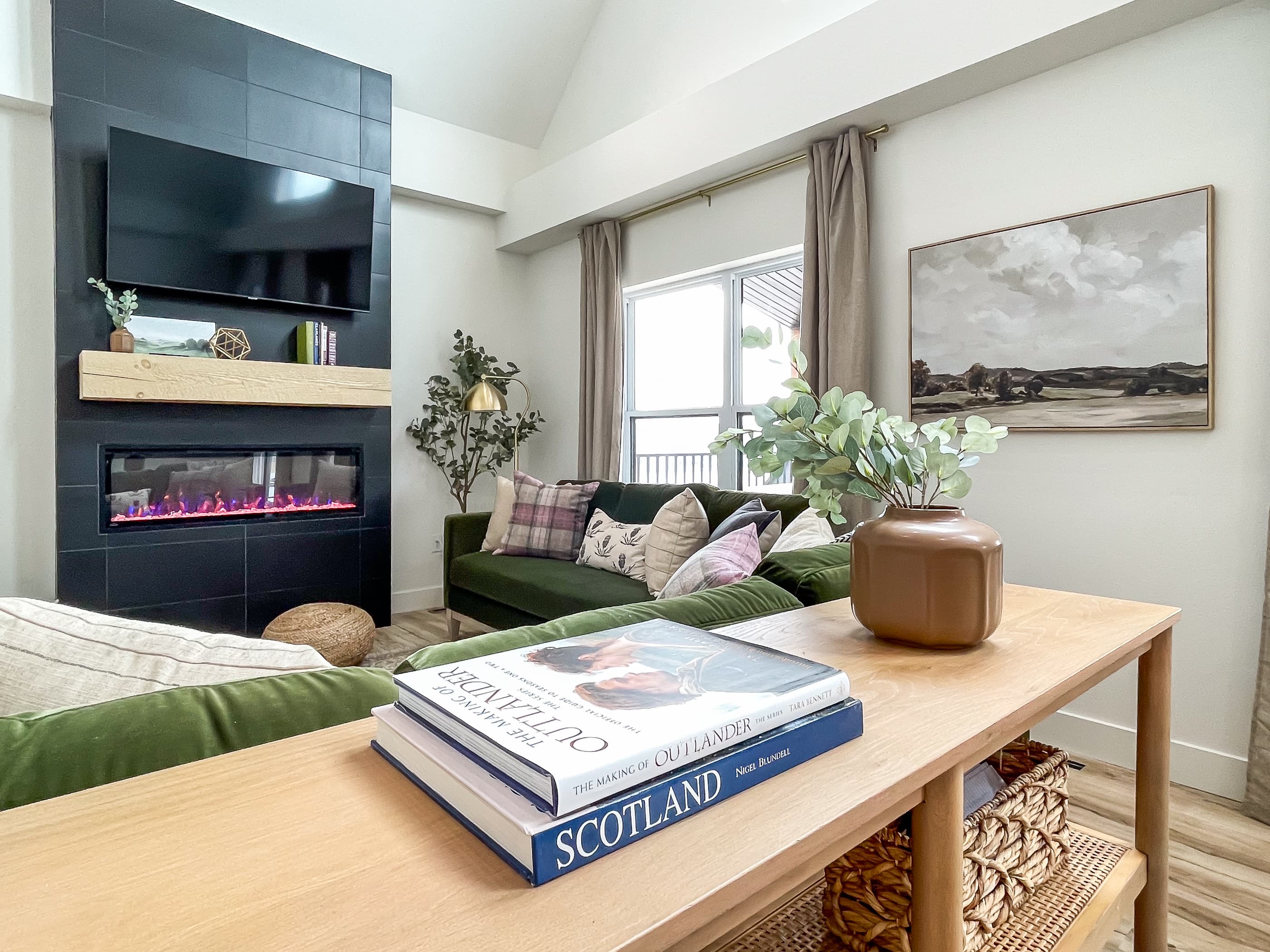 Cuddle up on the green velvet couches with the electric fireplace and TV