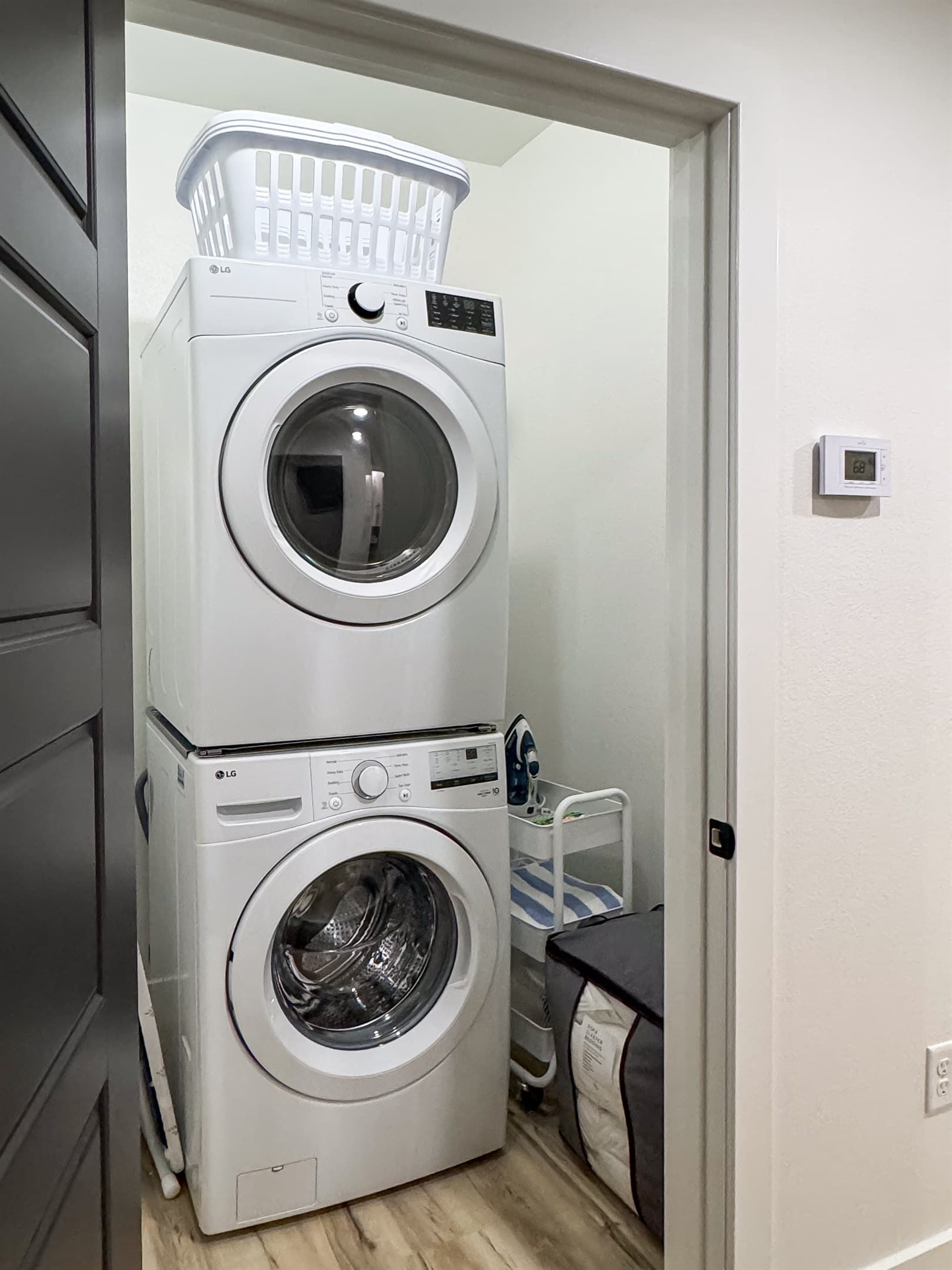 Washer/Dryer closet with pool towels, iron and board, and sleeper sofa linens