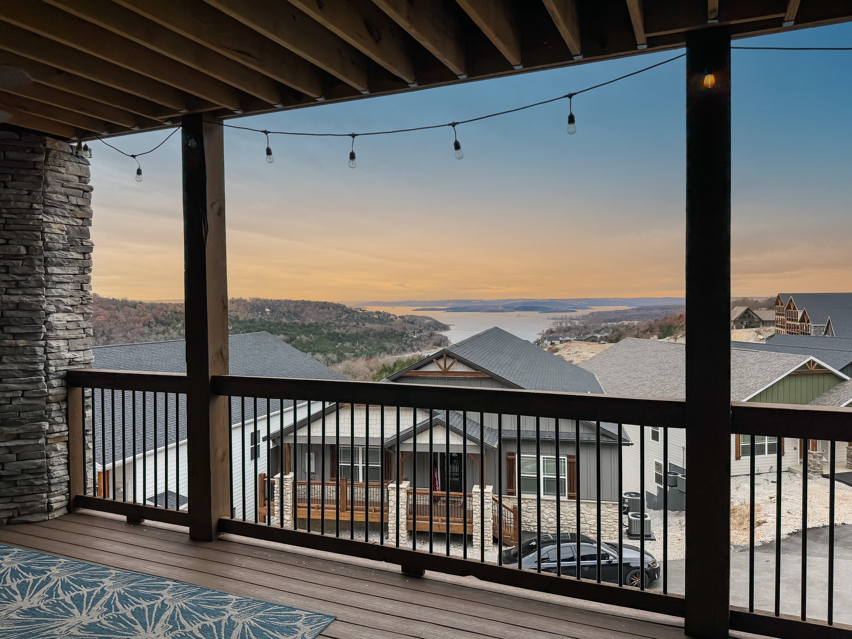 Main level deck with gas fireplace and sectional couch for lake viewing